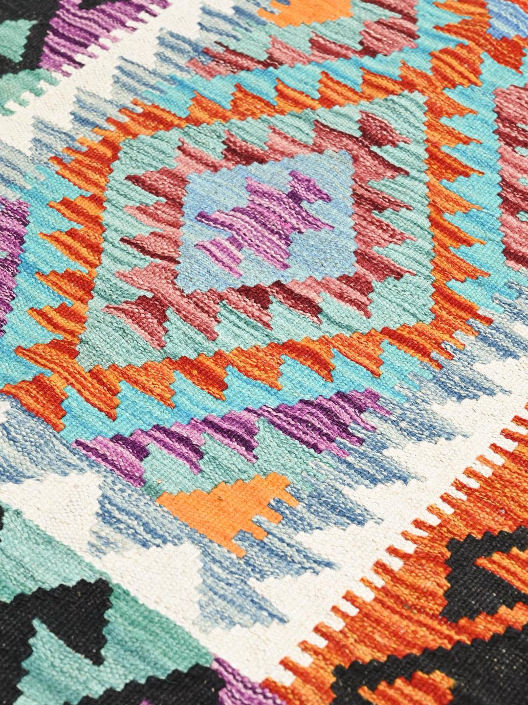 Een handgeweven loper uit Afghanistan met levendige, veelkleurige geometrische patronen.