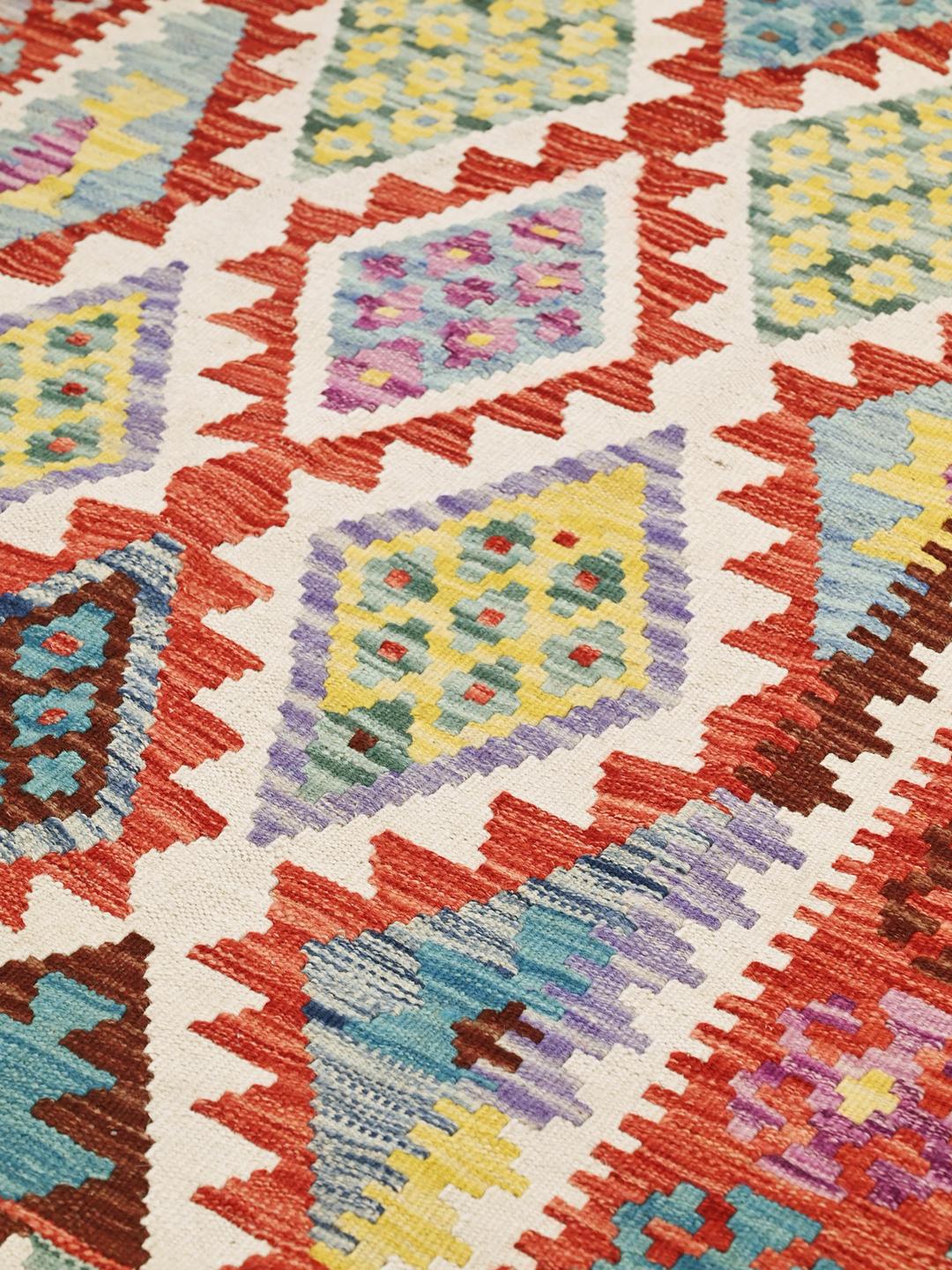 Een handgeweven Afghaans Kelim-kleed met een levendig, veelkleurig geometrisch patroon.