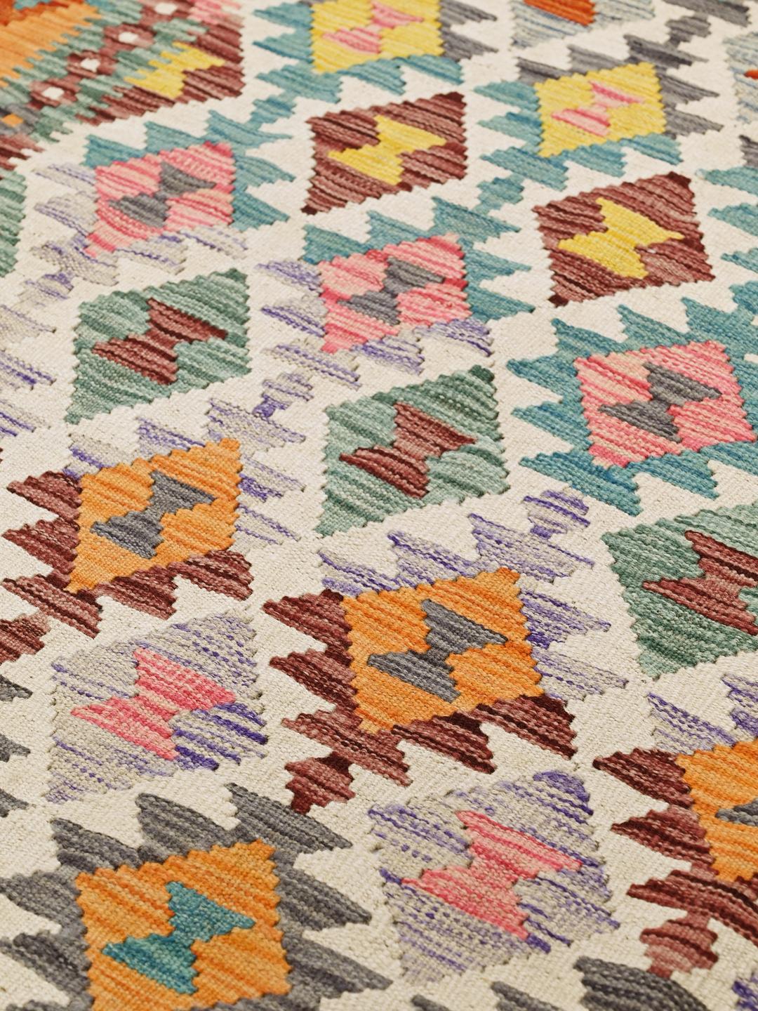 A vibrant rectangular hand-woven Kelim rug from Afghanistan with colourful geometric patterns.
