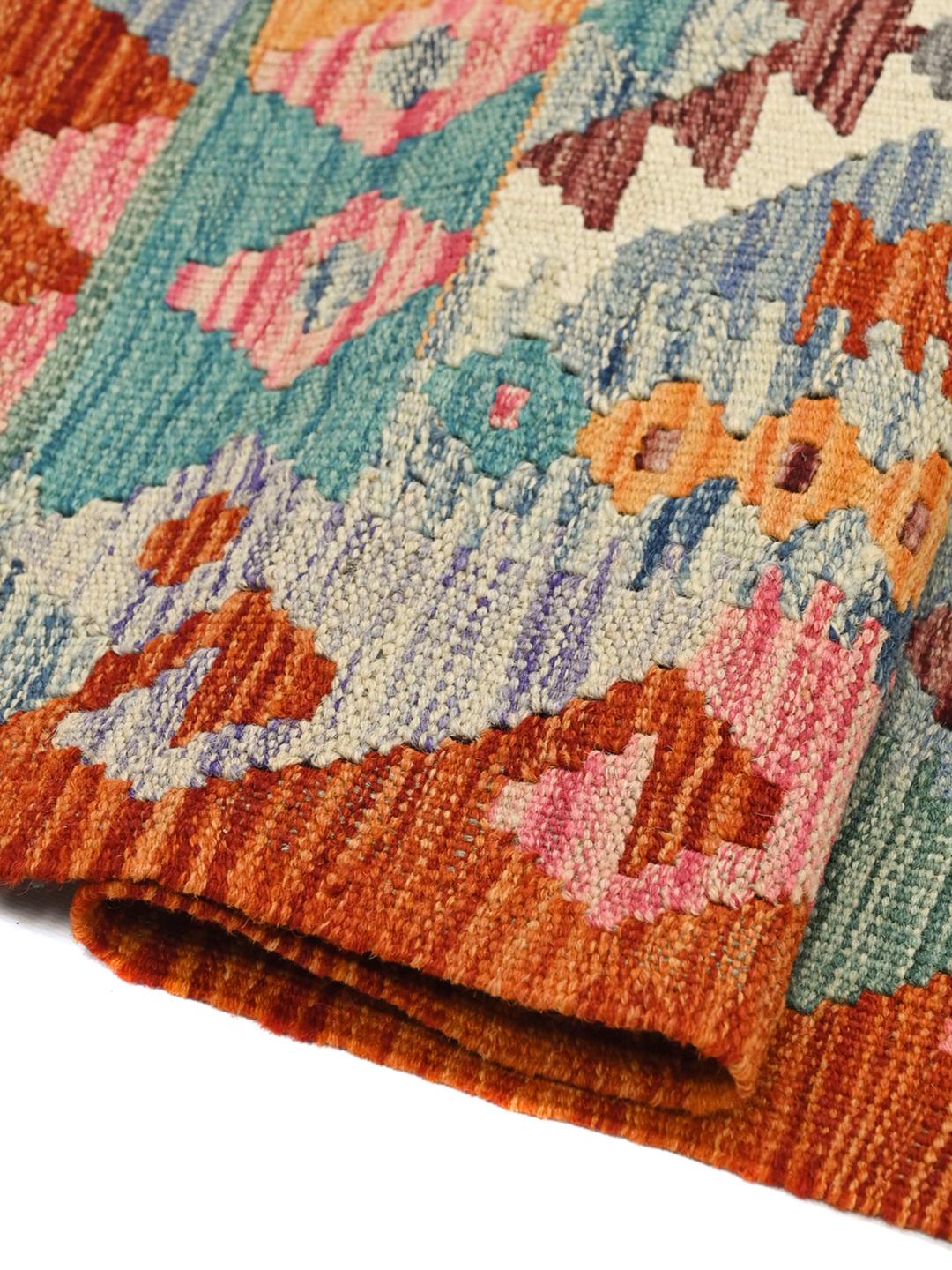A vibrant rectangular hand-woven Kelim rug from Afghanistan with colourful geometric patterns.