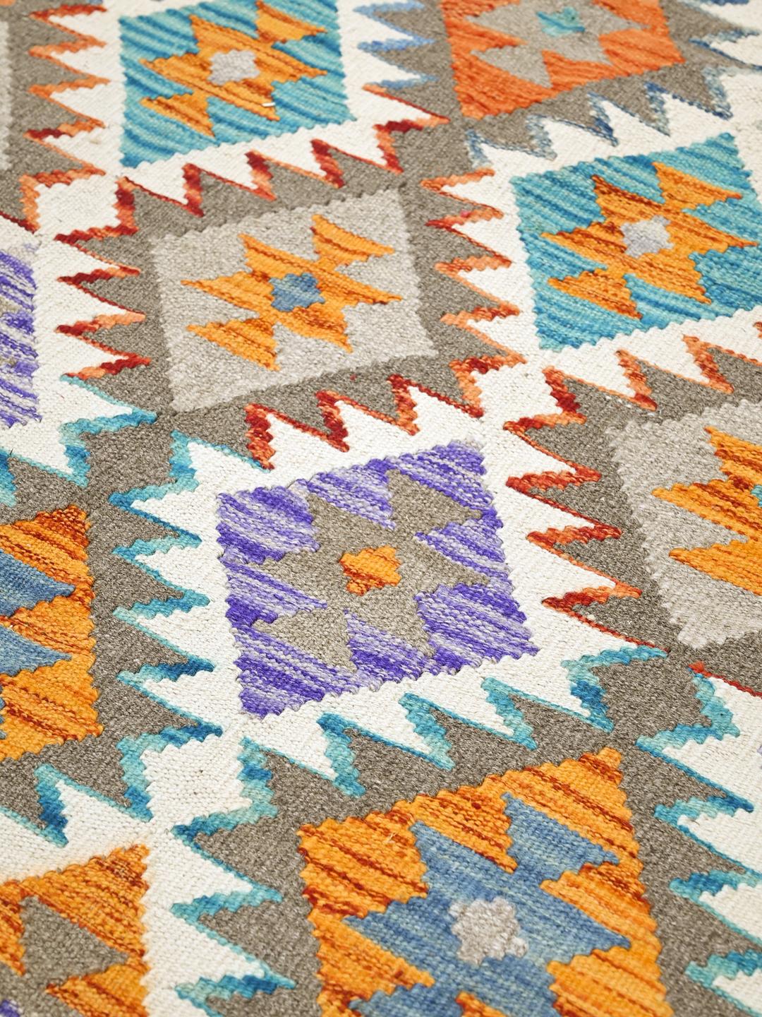 Hand-woven Afghan Kelim rug featuring a colourful geometric diamond pattern in a rectangular shape.