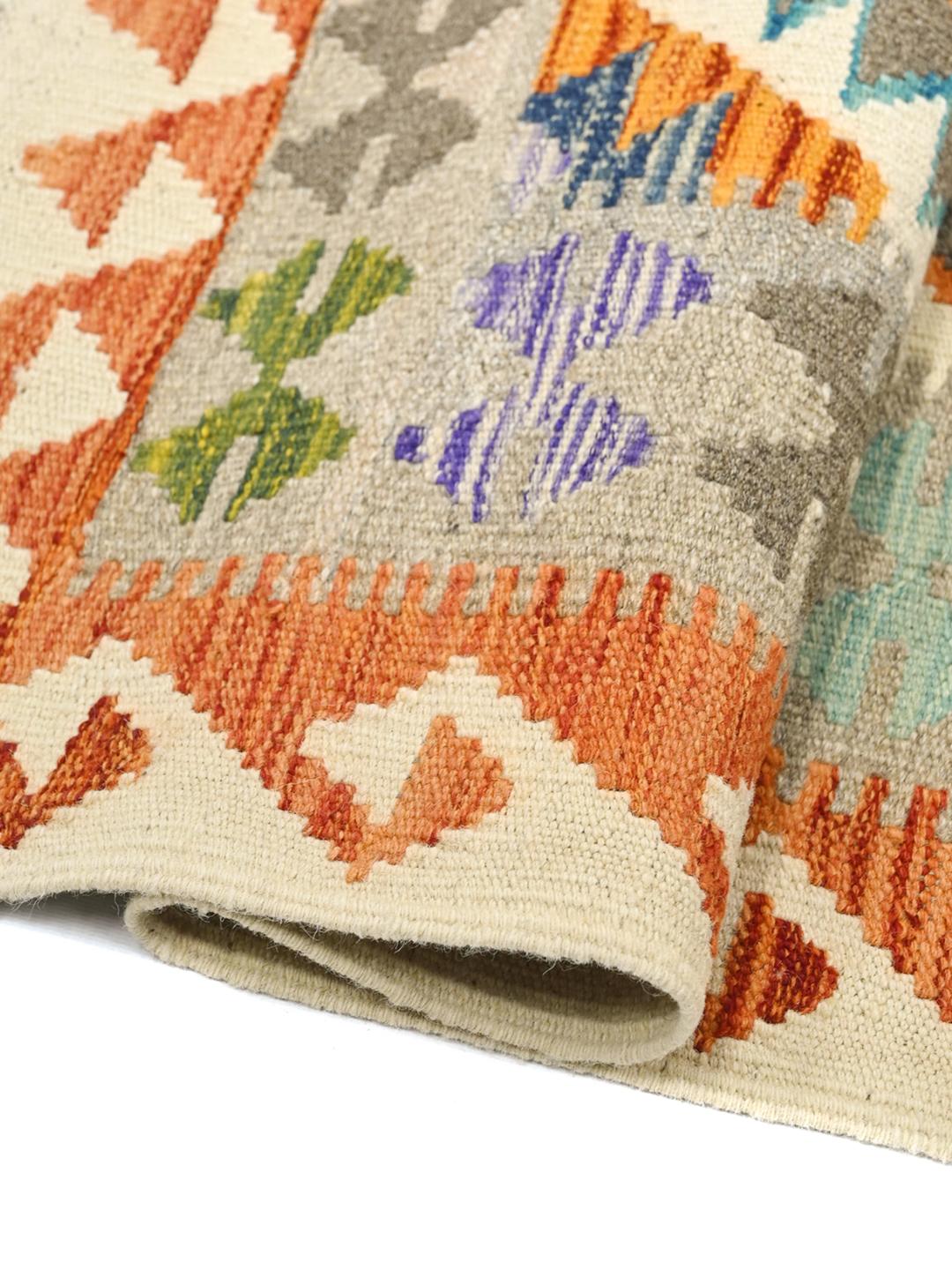 Hand-woven Afghan Kelim rug featuring a colourful geometric diamond pattern in a rectangular shape.