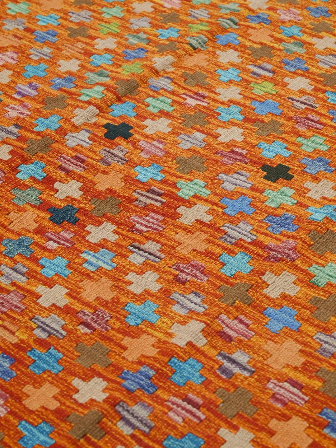 A hand-woven Afghan Kelim rug featuring a vibrant orange field with multi-coloured geometric crosses.