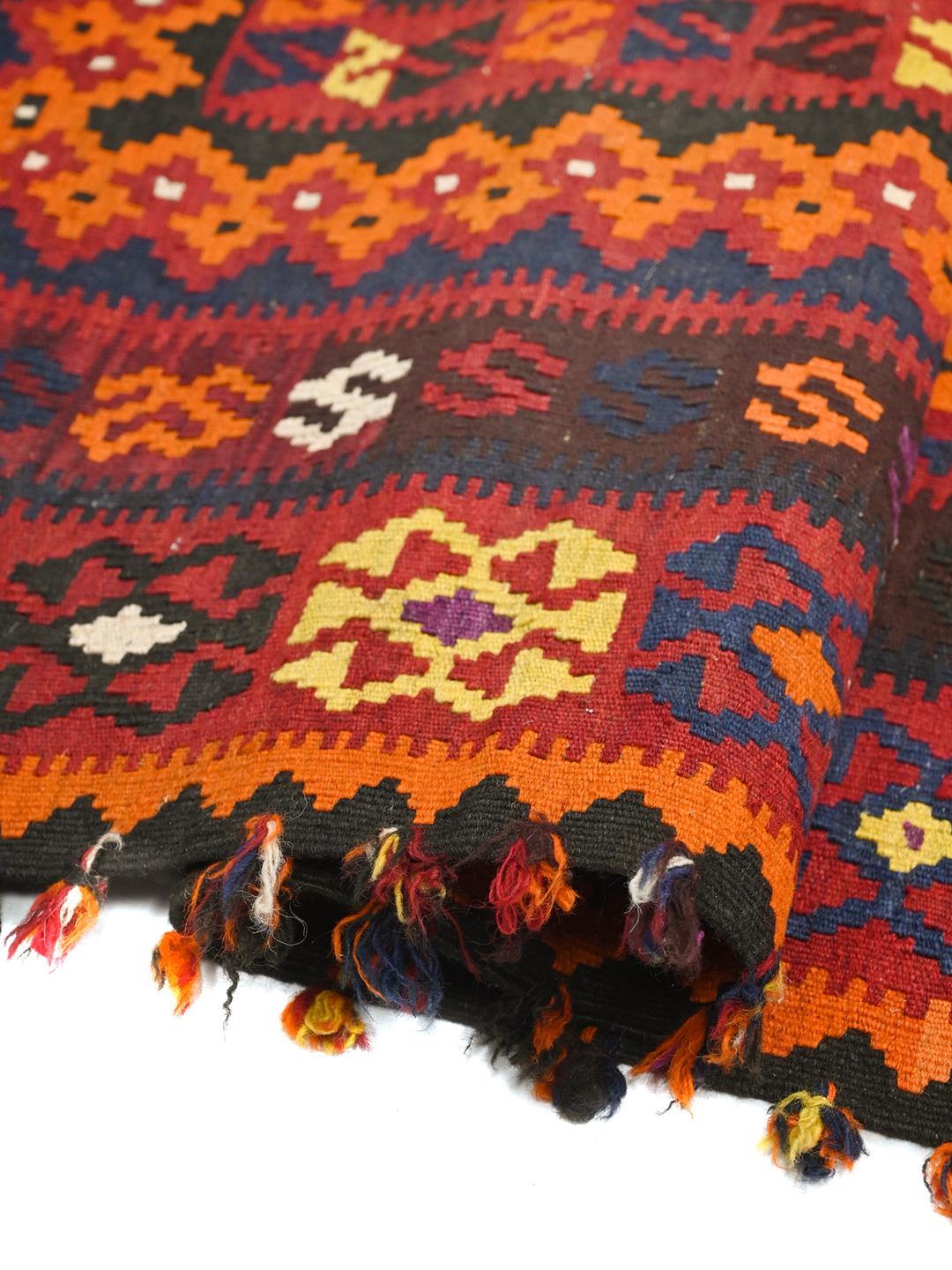 Een groot, handgeweven Kelim Maimane vloerkleed uit Afghanistan in tinten rood en blauw met geometrische patronen.