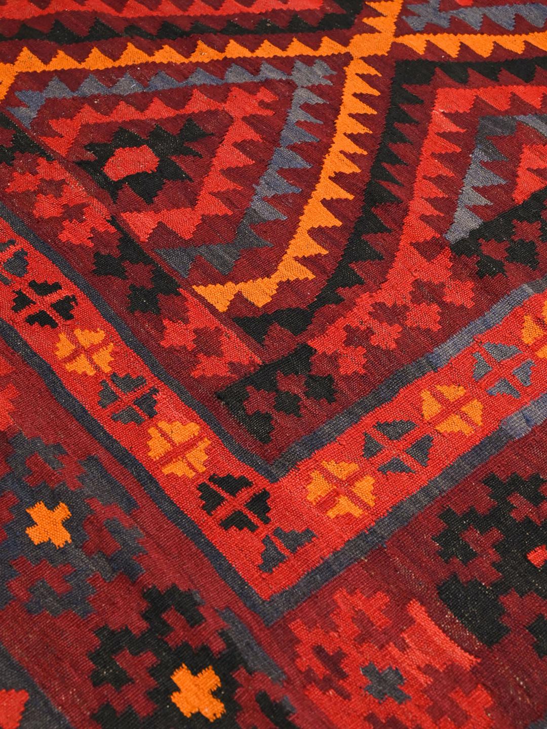 Håndvævet uldtæppe fra Afghanistan i mørkerøde og mulitfarvede geometriske mønstre