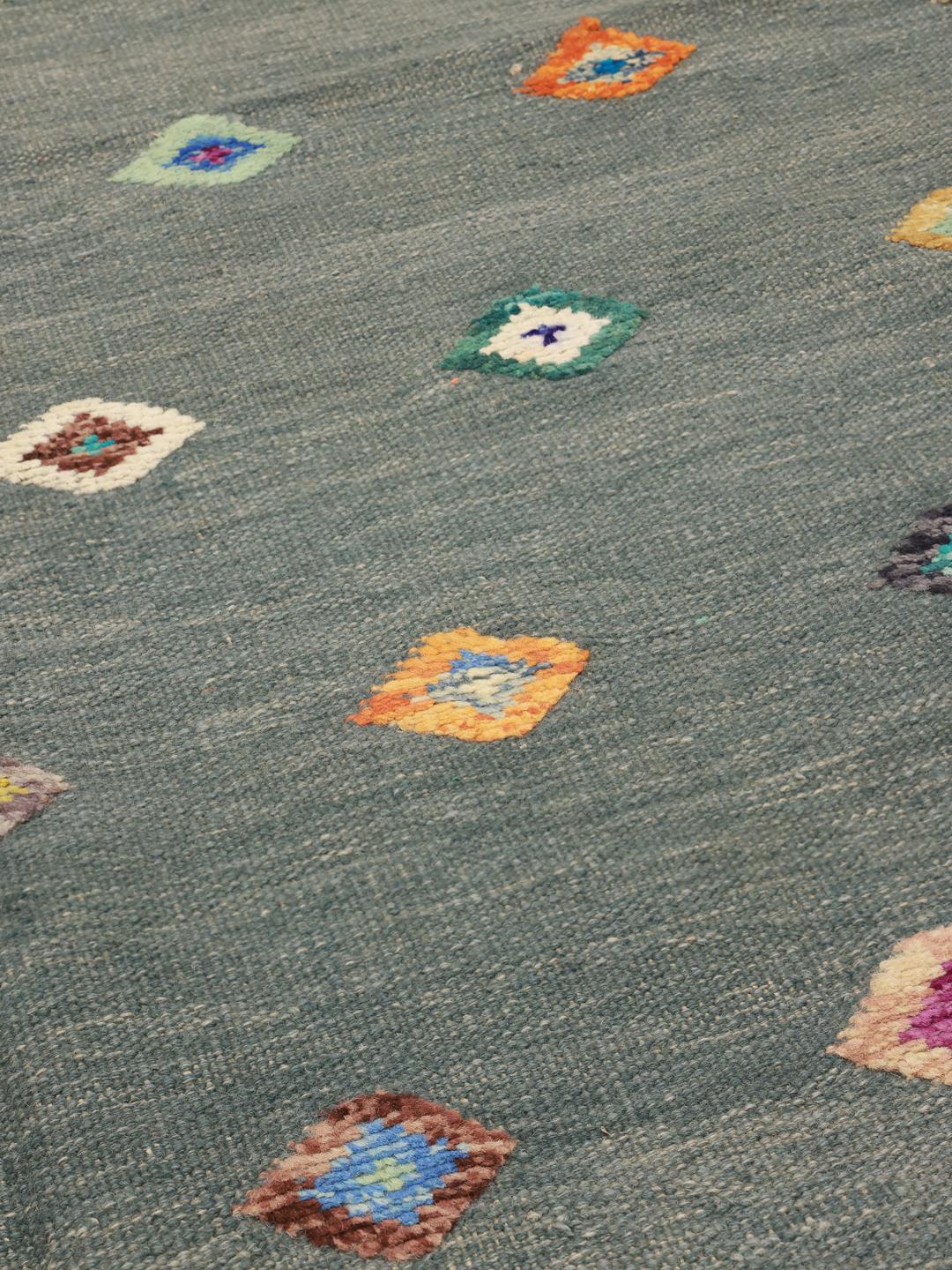 Tapete Kilim afegão tecido à mão com motivos de diamante num campo de cor verde-azulado escuro.