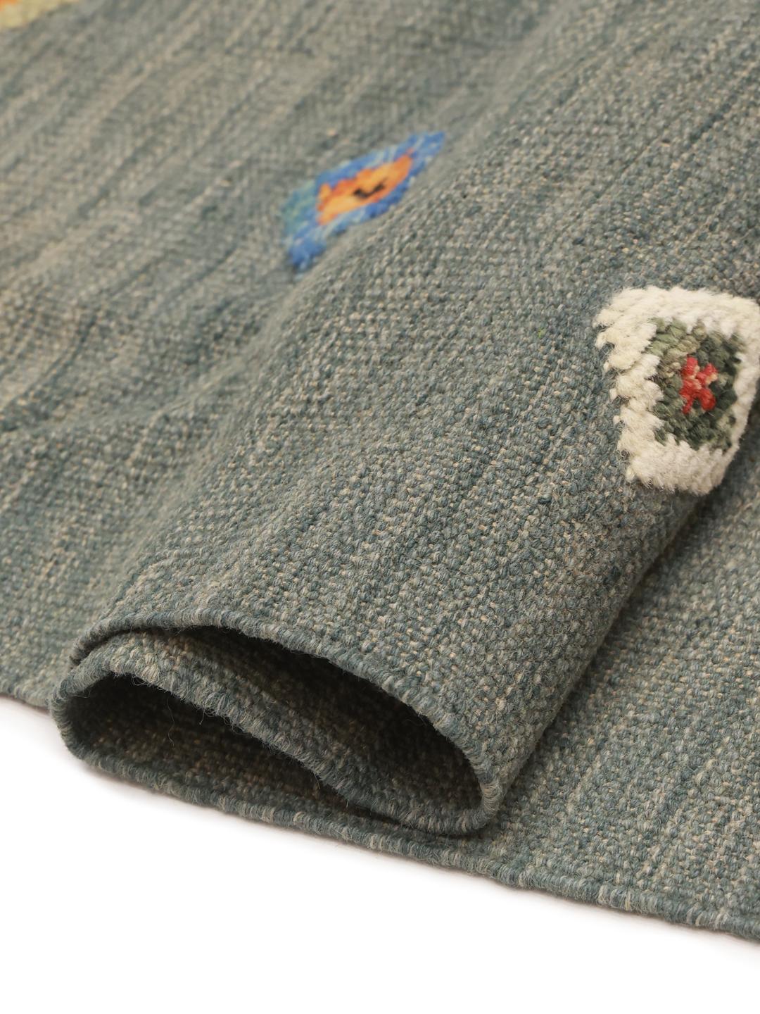 Tapete Kilim afegão tecido à mão com motivos de diamante num campo de cor verde-azulado escuro.