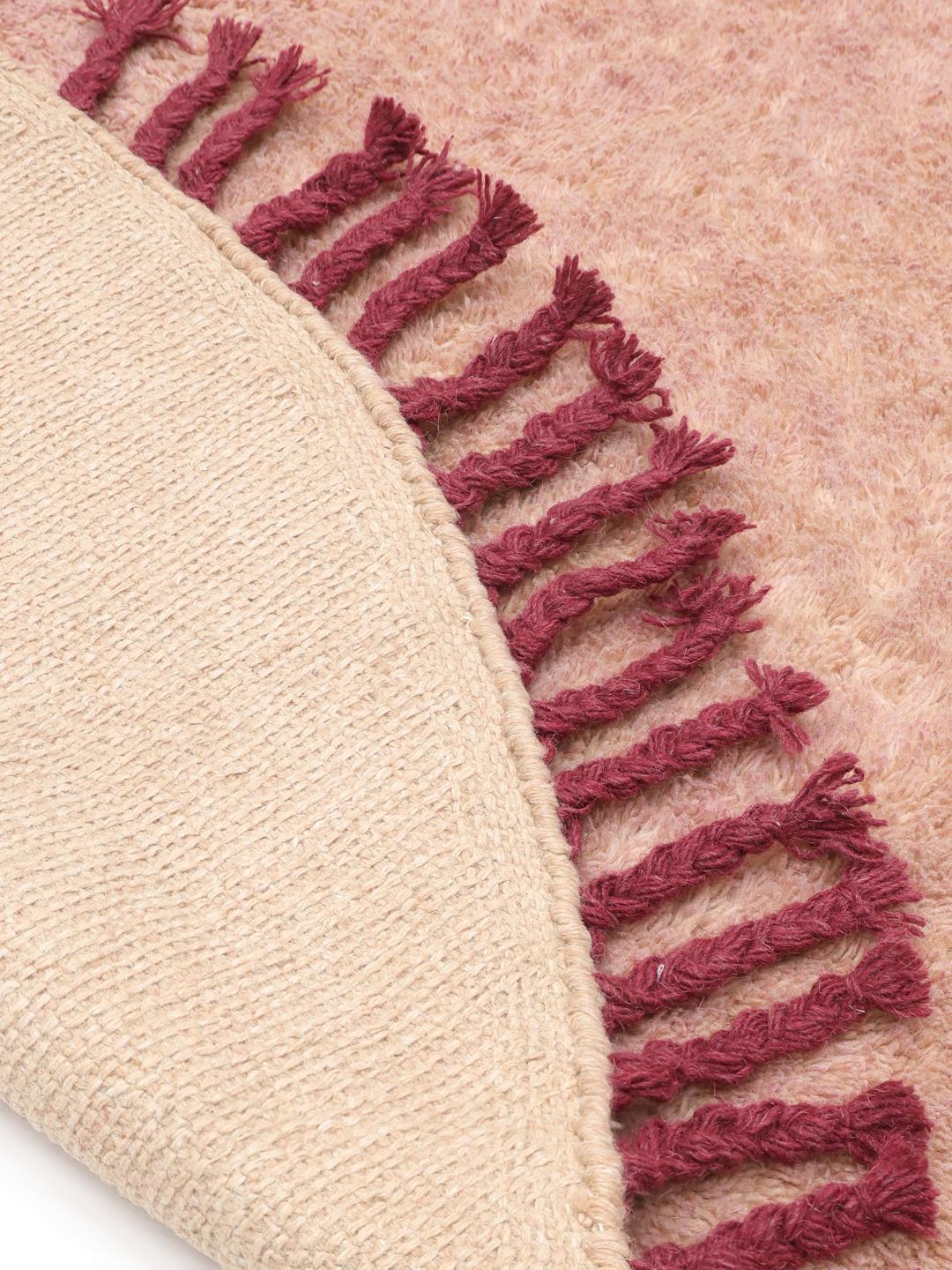 Roze rond tapijt met donkerrode franjes
