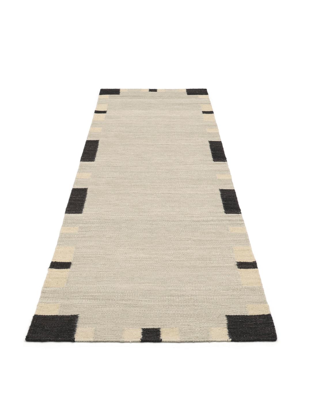Beige en zwarte loper tapijt met een geometrische rand