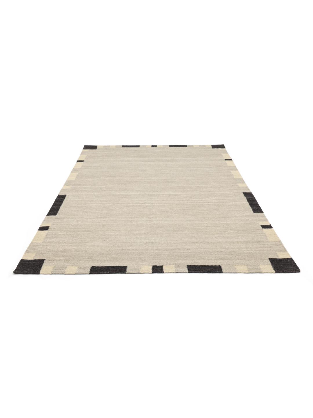 Beige tæppe med en mørk kant