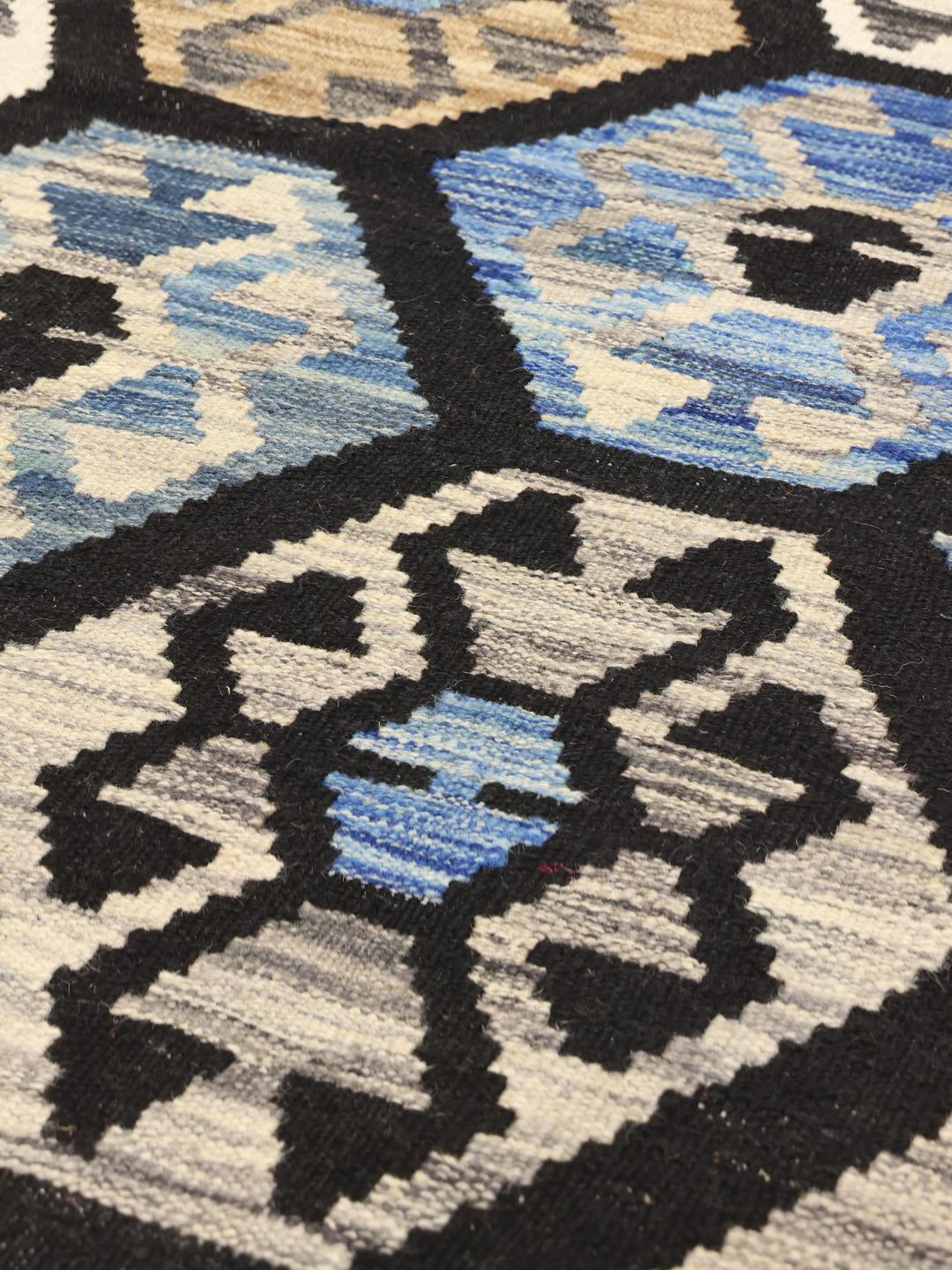 Handgeweven Afghan Kelim-tapijt met geometrische honingraatpatronen in blauw, bruin en wit.