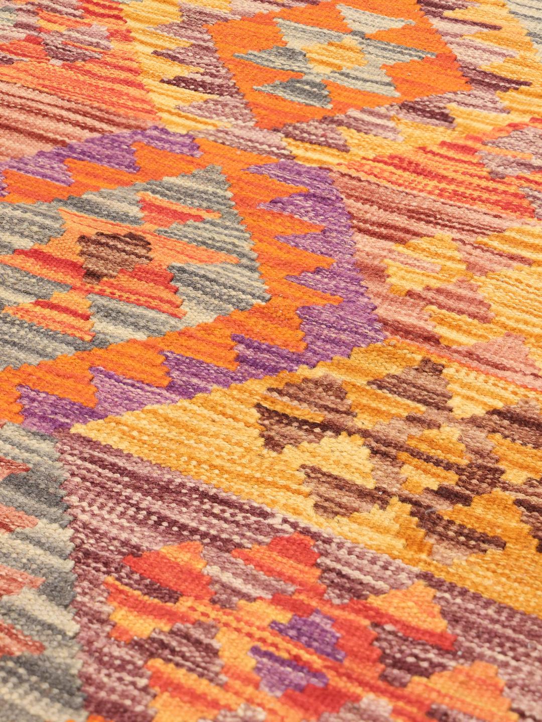Hand-woven Afghan Kelim rug featuring vibrant geometric patterns in multicolor wool.