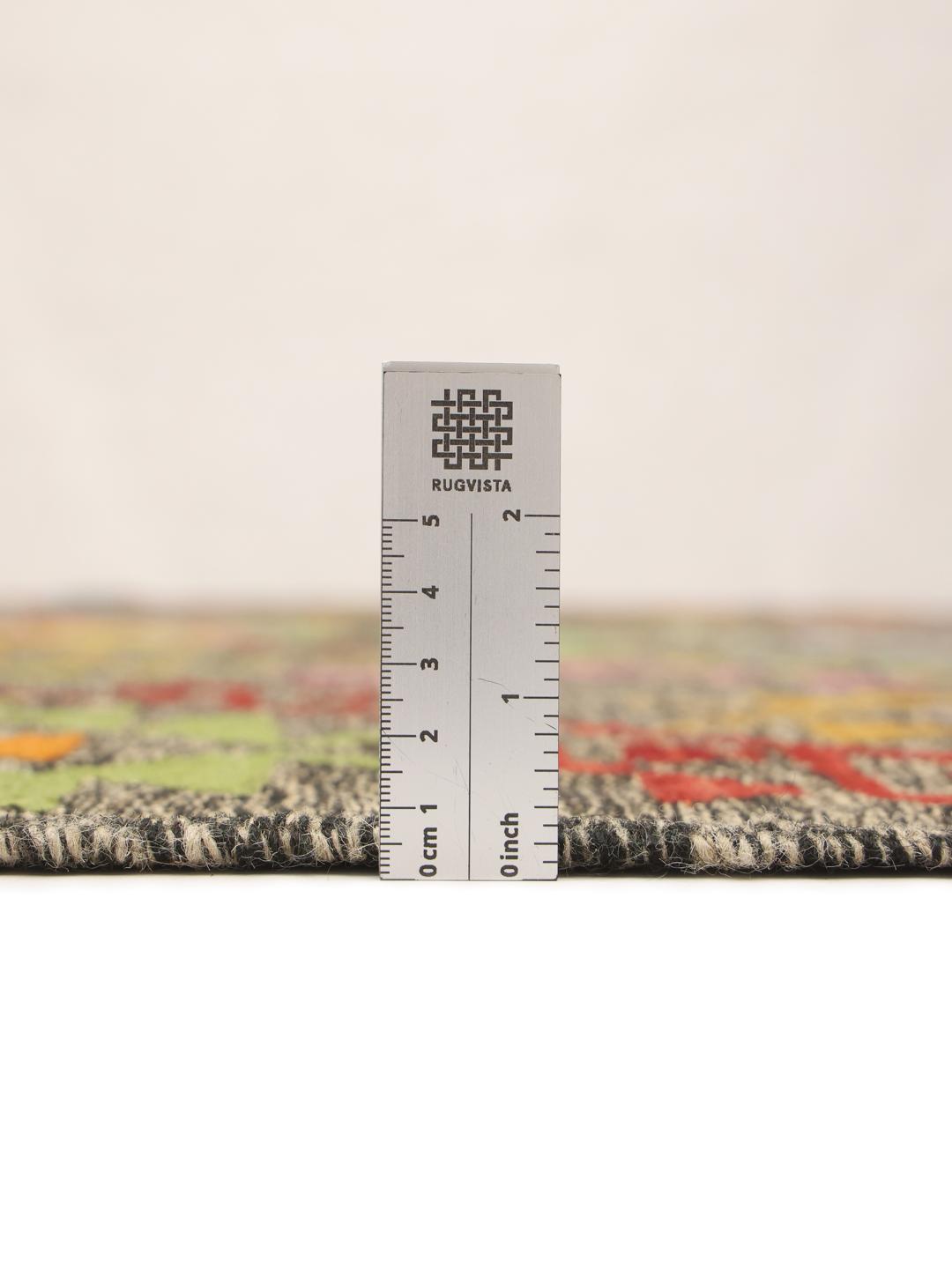 Hand-woven Afghan Kelim rug featuring a dark background with vibrant geometric patterns