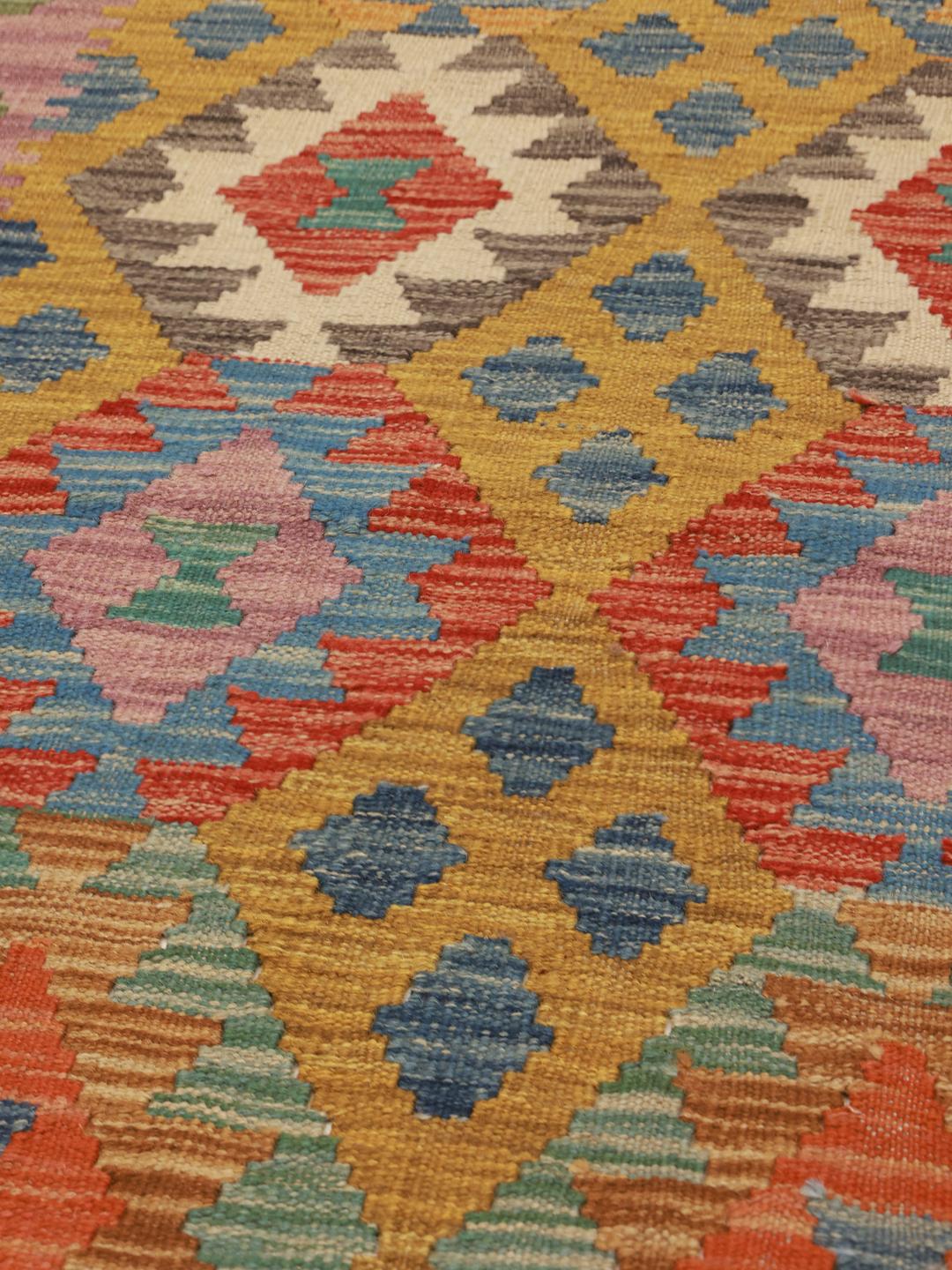 A hand-woven, multicolored Afghan runner rug with a diamond pattern