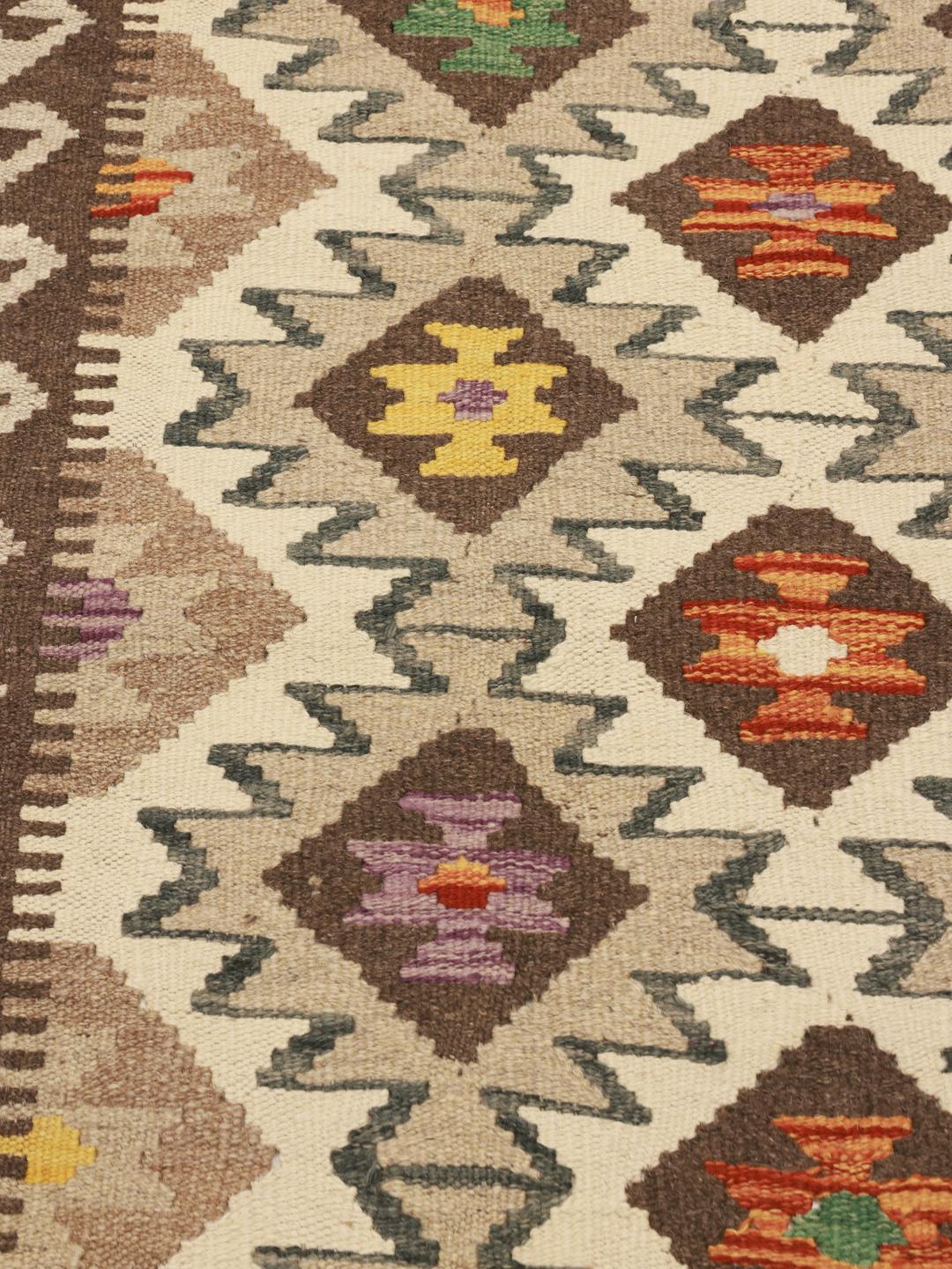 Hand-woven Afghan runner with geometric diamond patterns in beige and multicolor