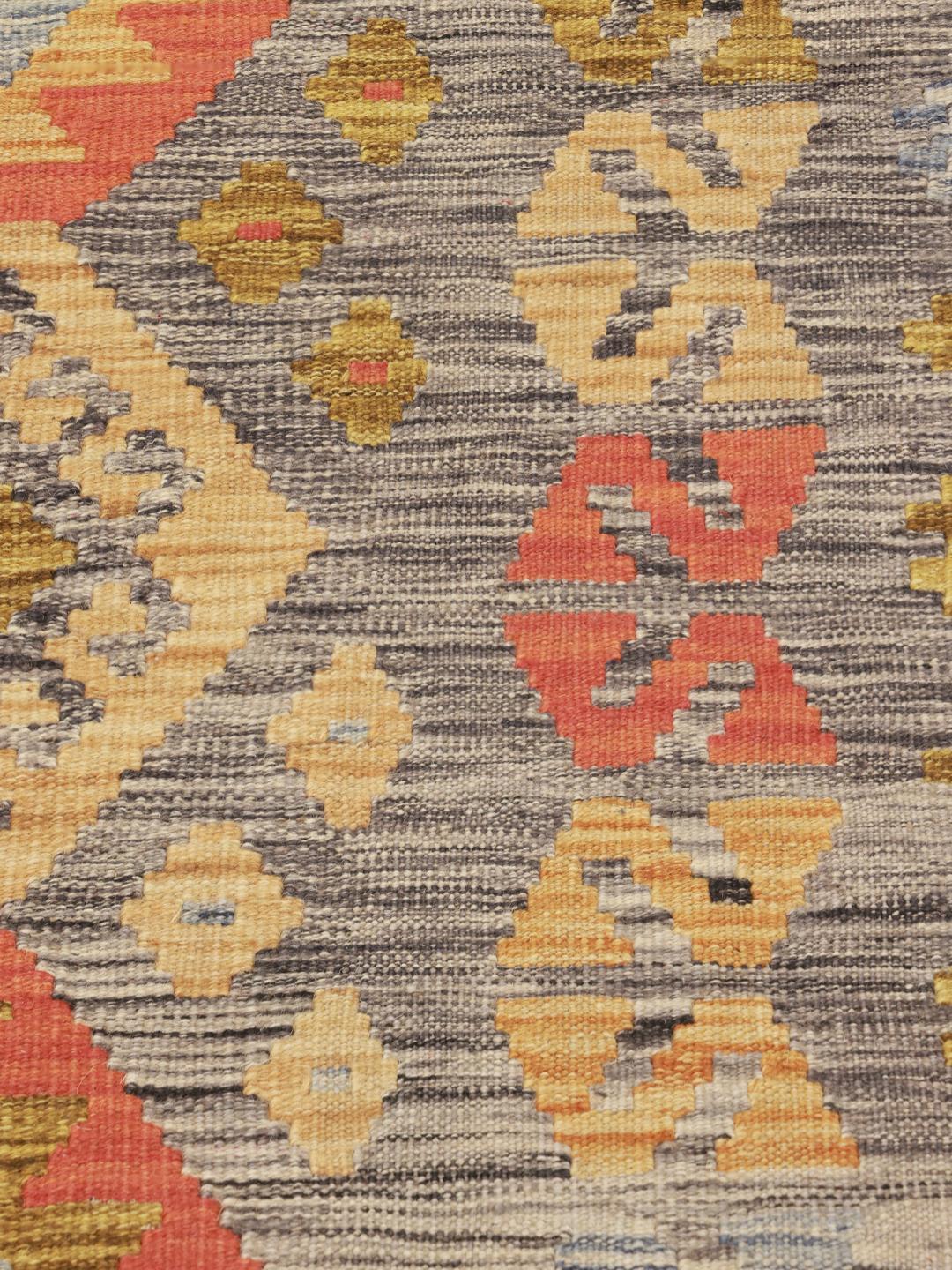 Hand-woven Afghan Kelim rug with geometric diamond patterns in multicolor wool.