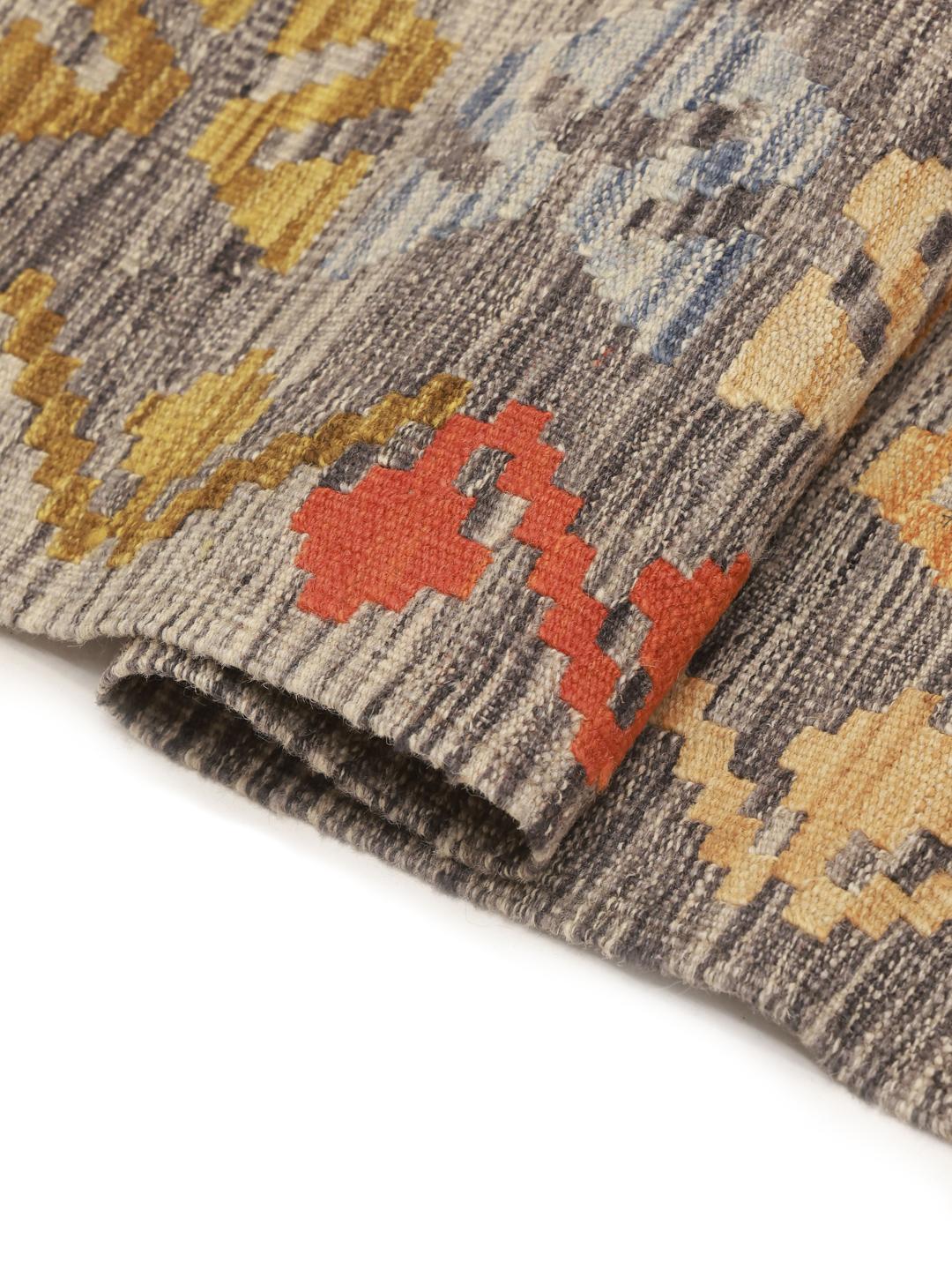 Hand-woven Afghan Kelim rug with geometric diamond patterns in multicolor wool.