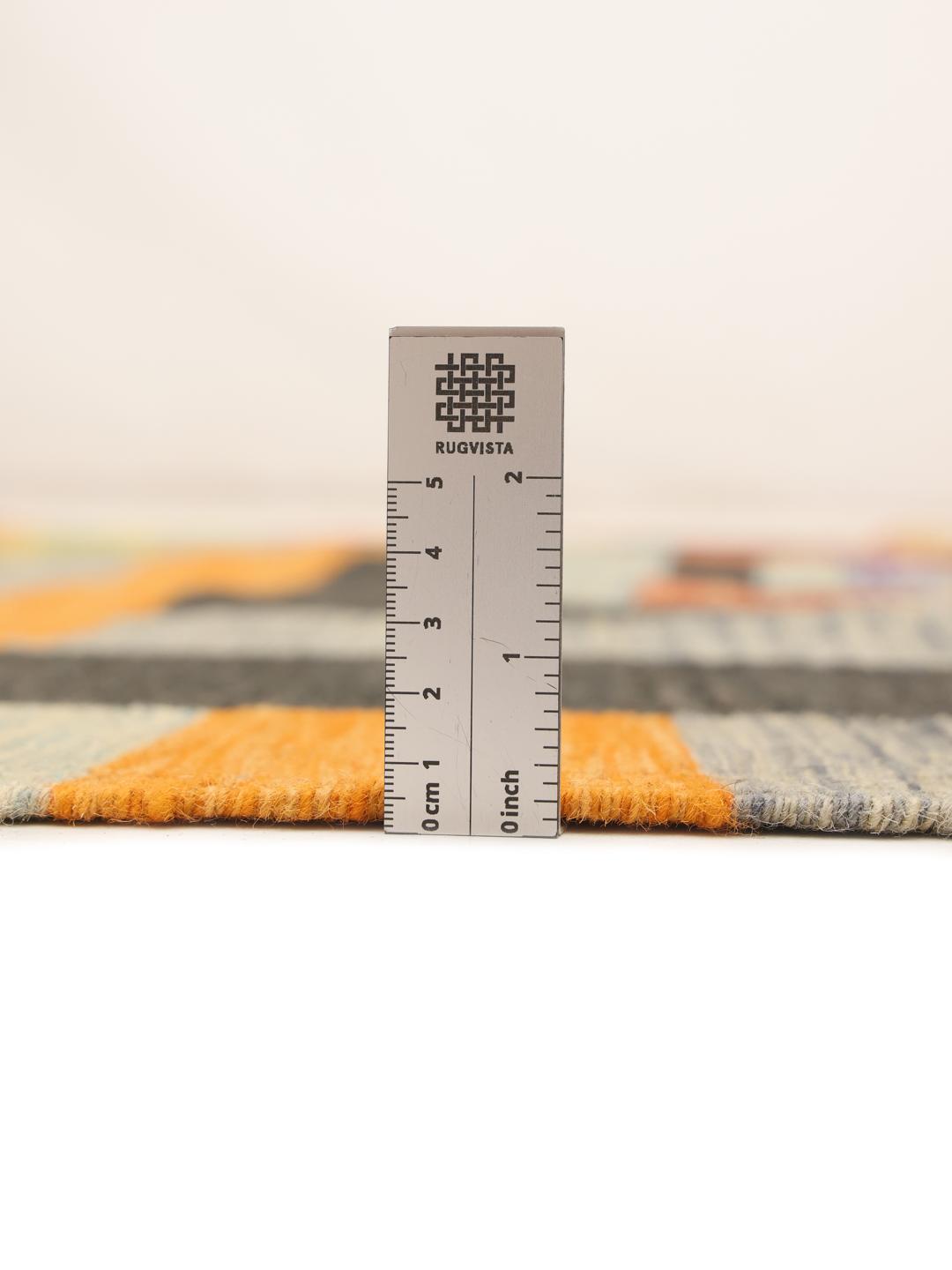 A rectangular, hand-woven Afghan Kilim rug featuring a vibrant, multi-coloured striped and geometric pattern.