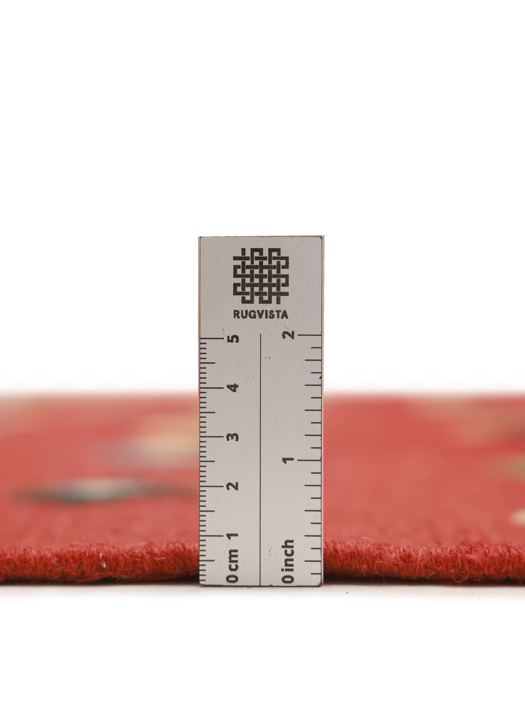 Um tapete retangular Kelim Nimbaft afegão com um campo vermelho vibrante e pequenos motivos geométricos de diamante multicoloridos.