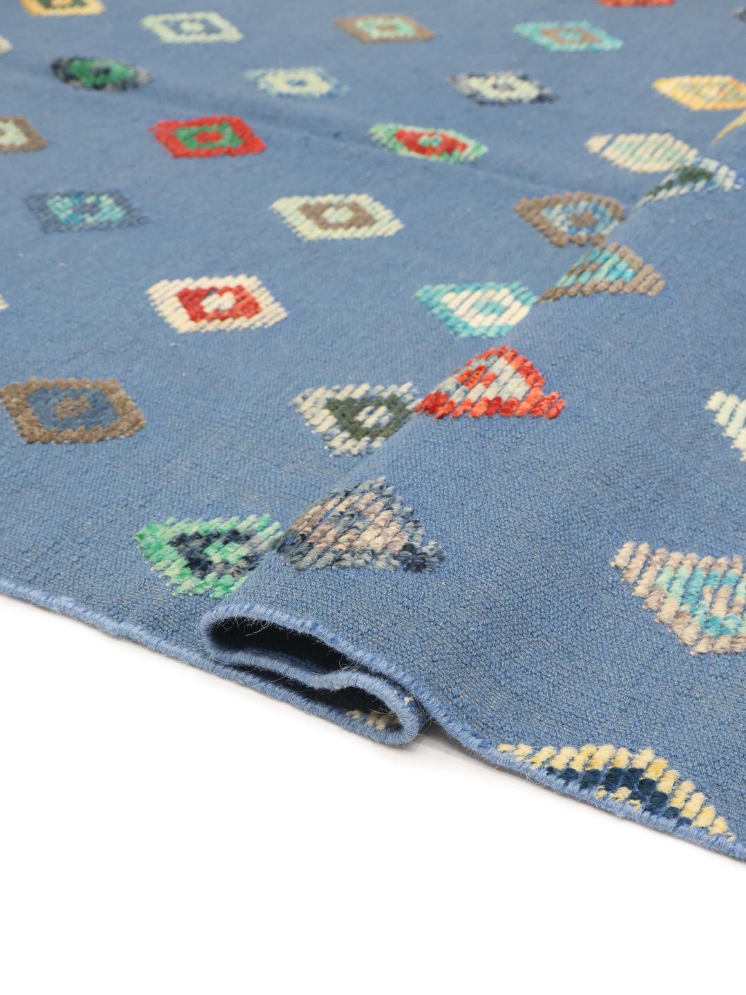 Hand-woven Afghan Kilim rug with multicoloured diamond patterns on a blue field