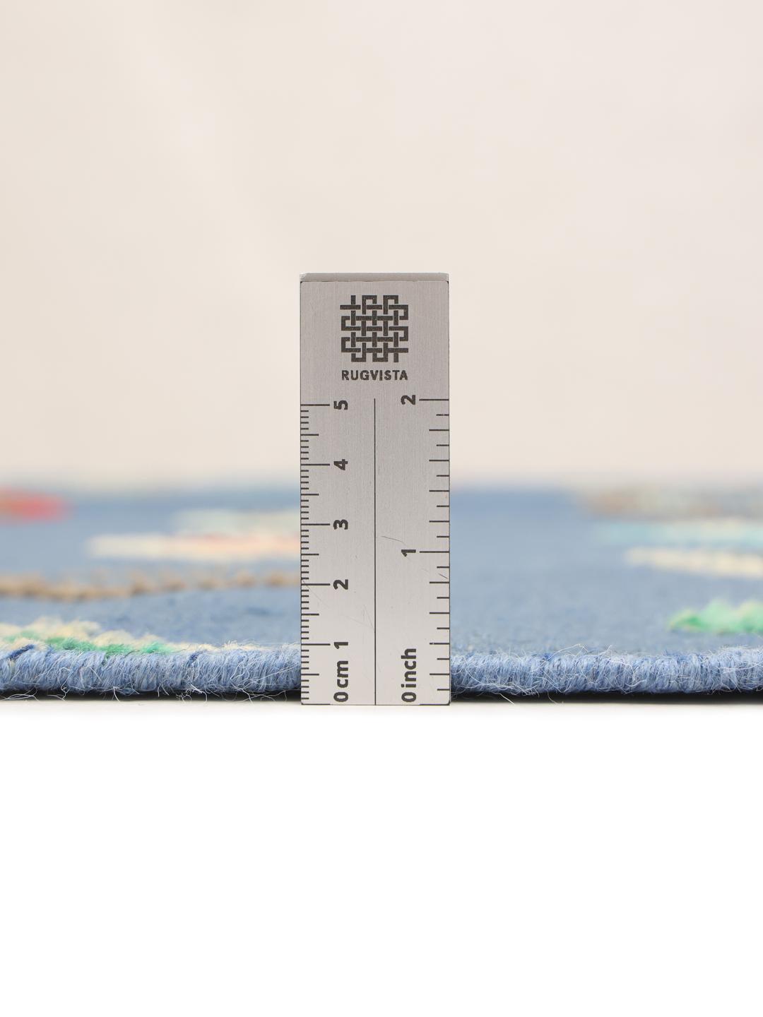 Hand-woven Afghan Kilim rug with multicoloured diamond patterns on a blue field