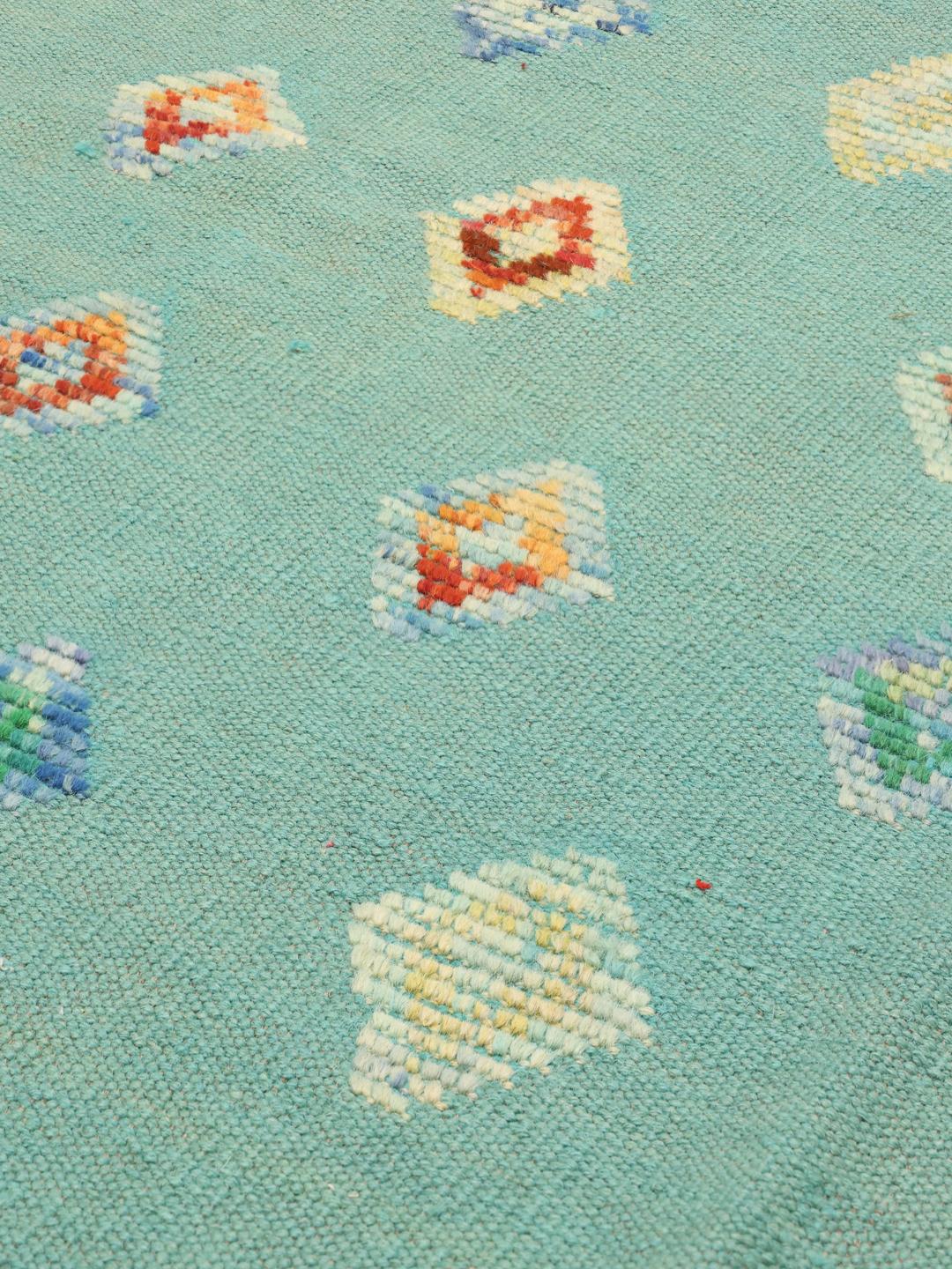 Hand-woven Afghan Kelim Nimbaft rug with a teal field and multicolour diamond patterns.