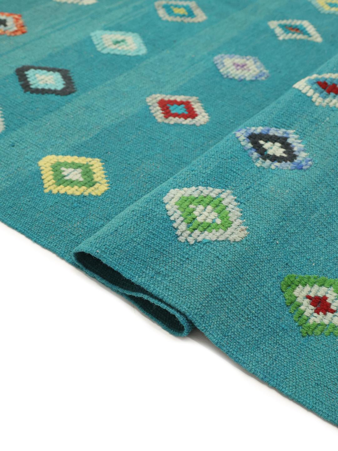Handgeweven Afghaans Kelim kleed in een levendige blauwgroene kleur met kleurrijke geometrische ruitpatronen.