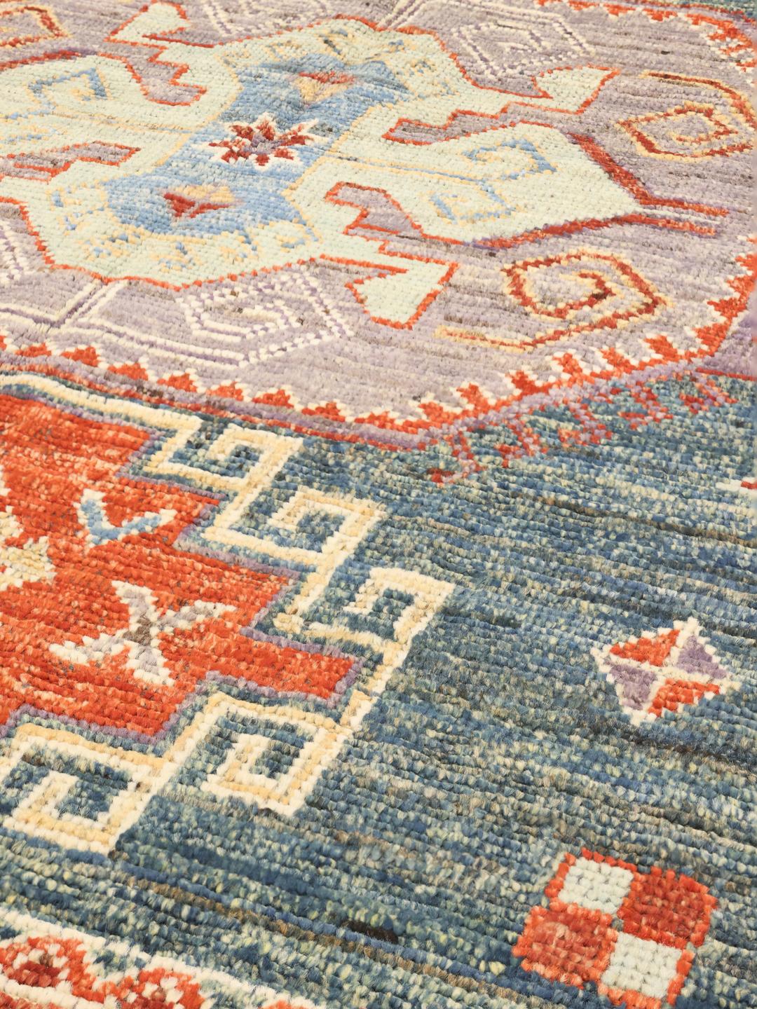 Hand-knotted Kazak rug from Afghanistan with a blue and red geometric pattern.