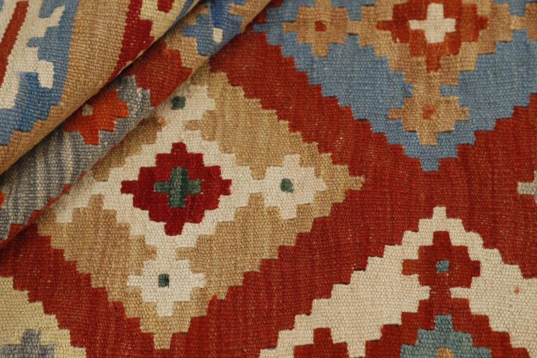Handgeweven rechthoekige kelim uit het Midden-Oosten met geometrische ruitpatronen in rode, beige en blauwe wol.