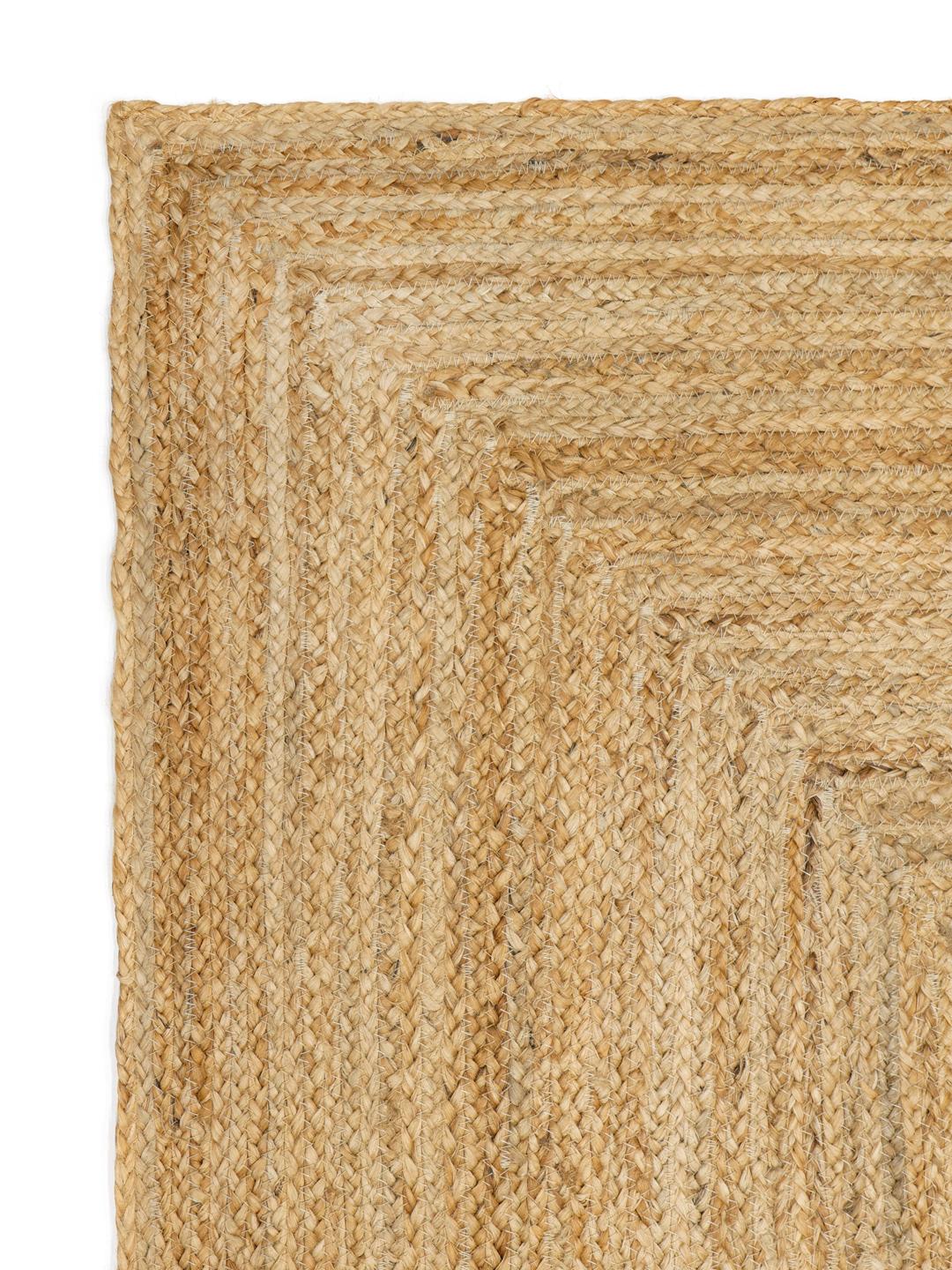 Beige tæppe med et naturligt flettet kantdesign