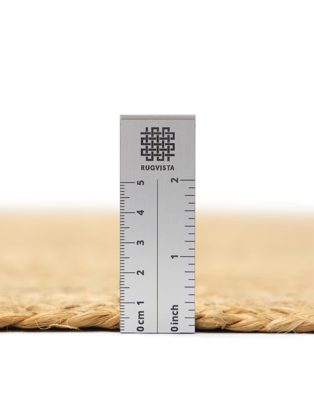 Beige tæppe med et naturligt flettet kantdesign