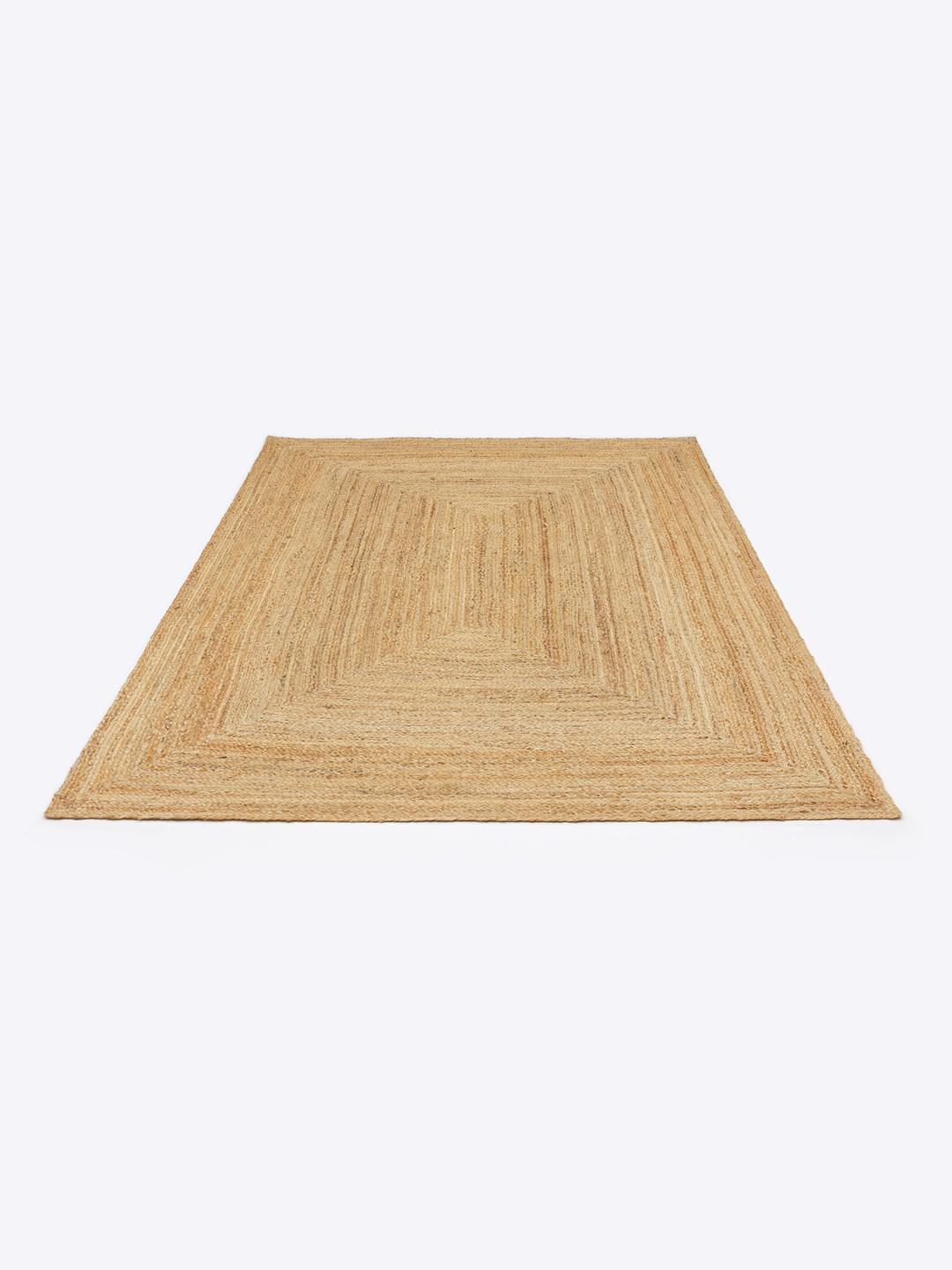 Tapis beige avec un design de bordure tressée naturelle