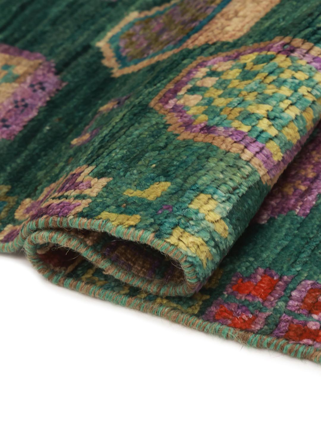 Hand-knotted Afghan rug with a vibrant green field and colourful geometric motifs.