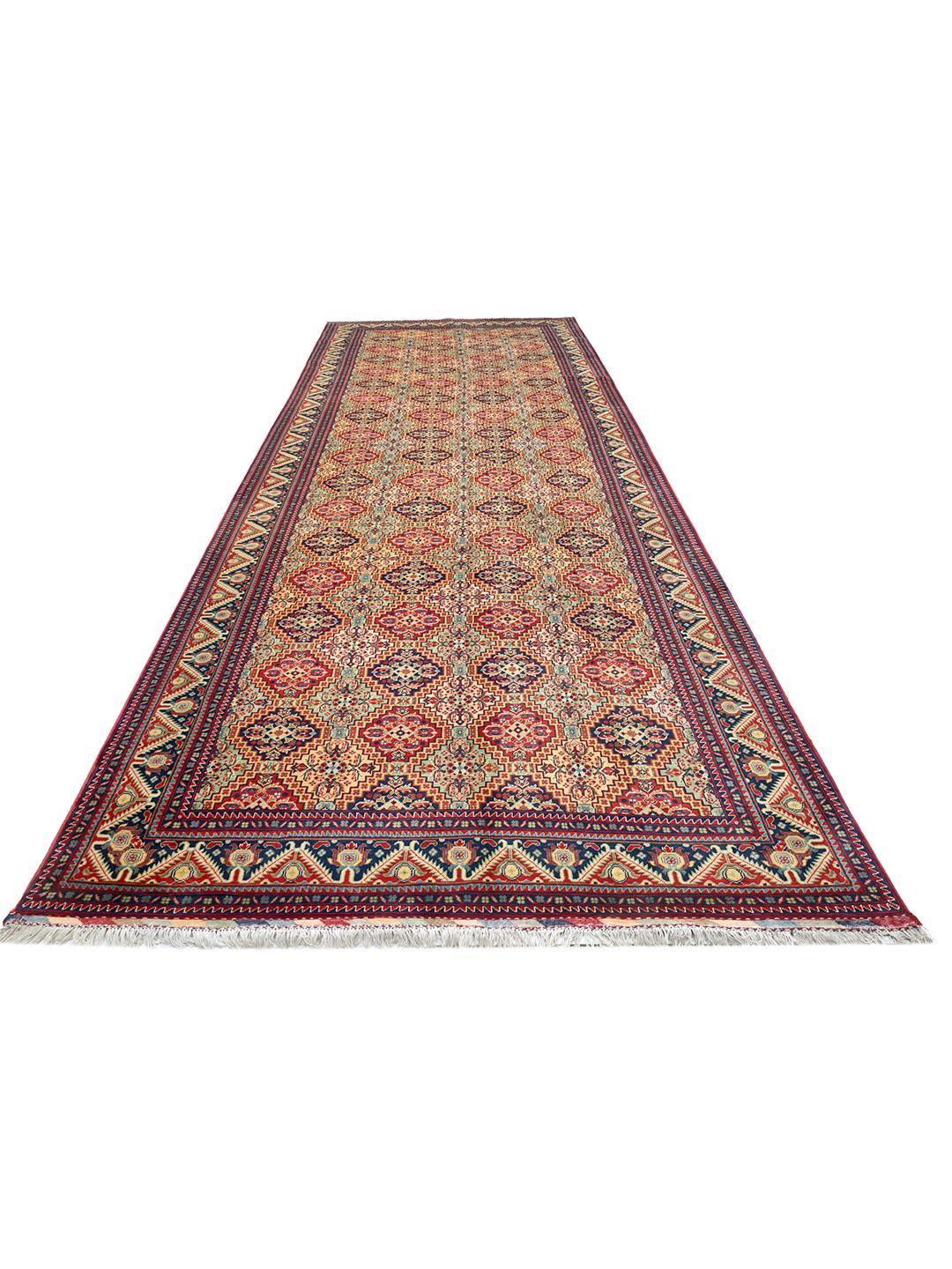 Handmade runner rug from Afghanistan in red with traditional patterns.