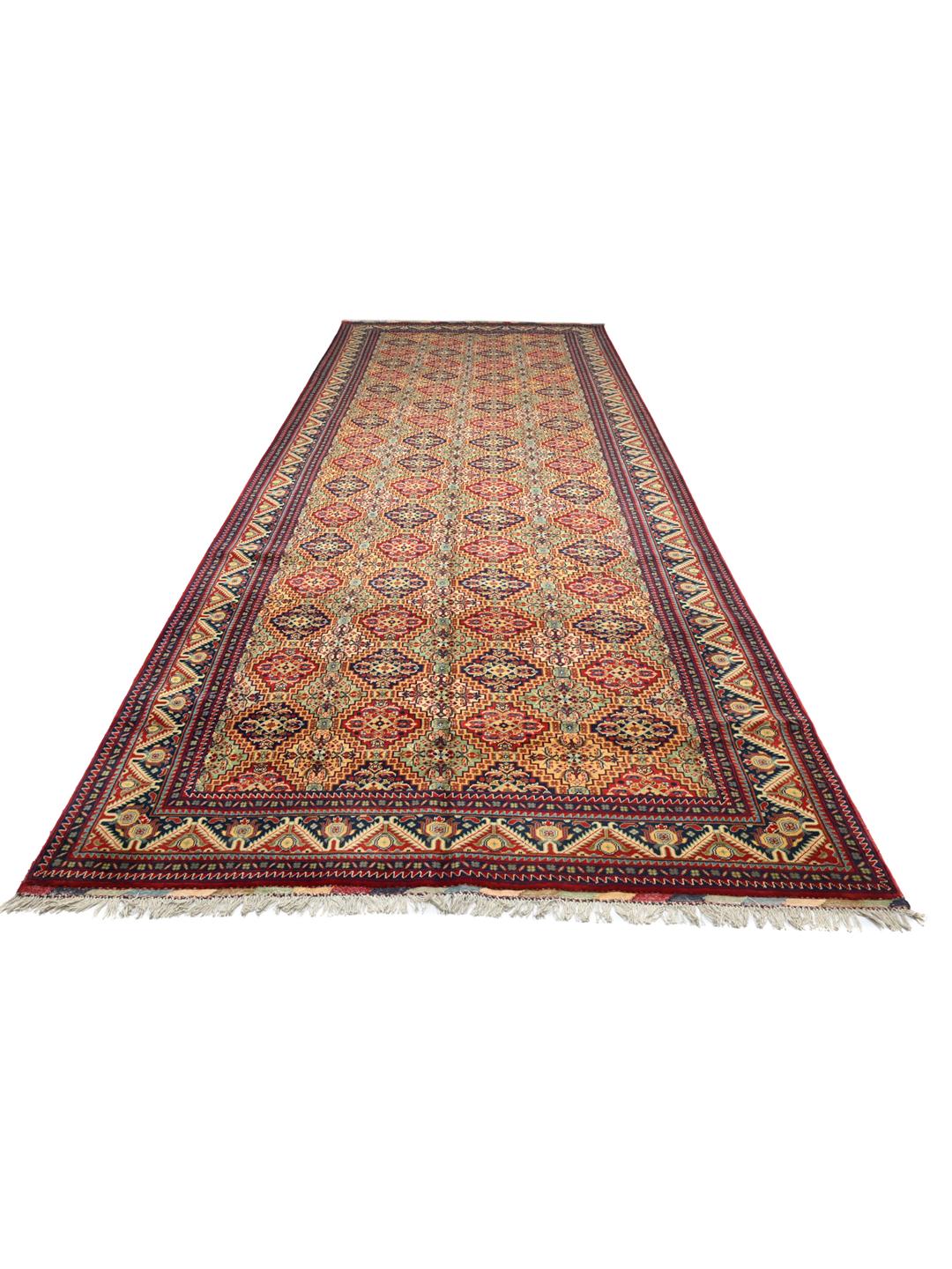 Handmade runner rug from Afghanistan in red with traditional patterns.