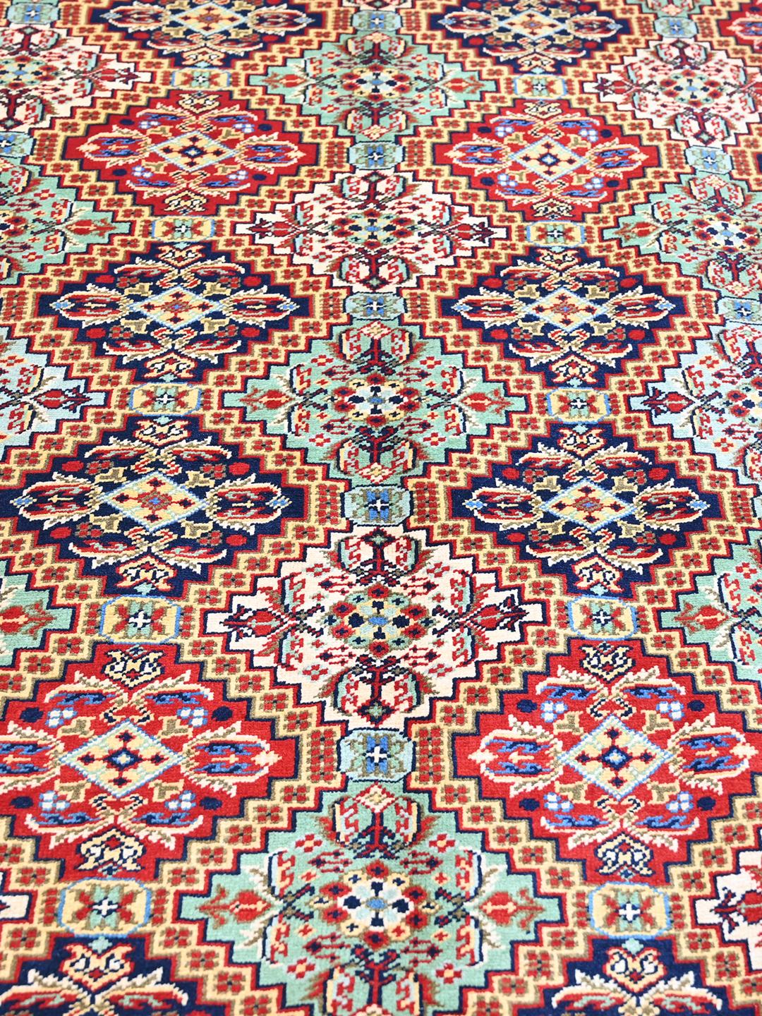 Handmade runner rug from Afghanistan in red with traditional patterns.