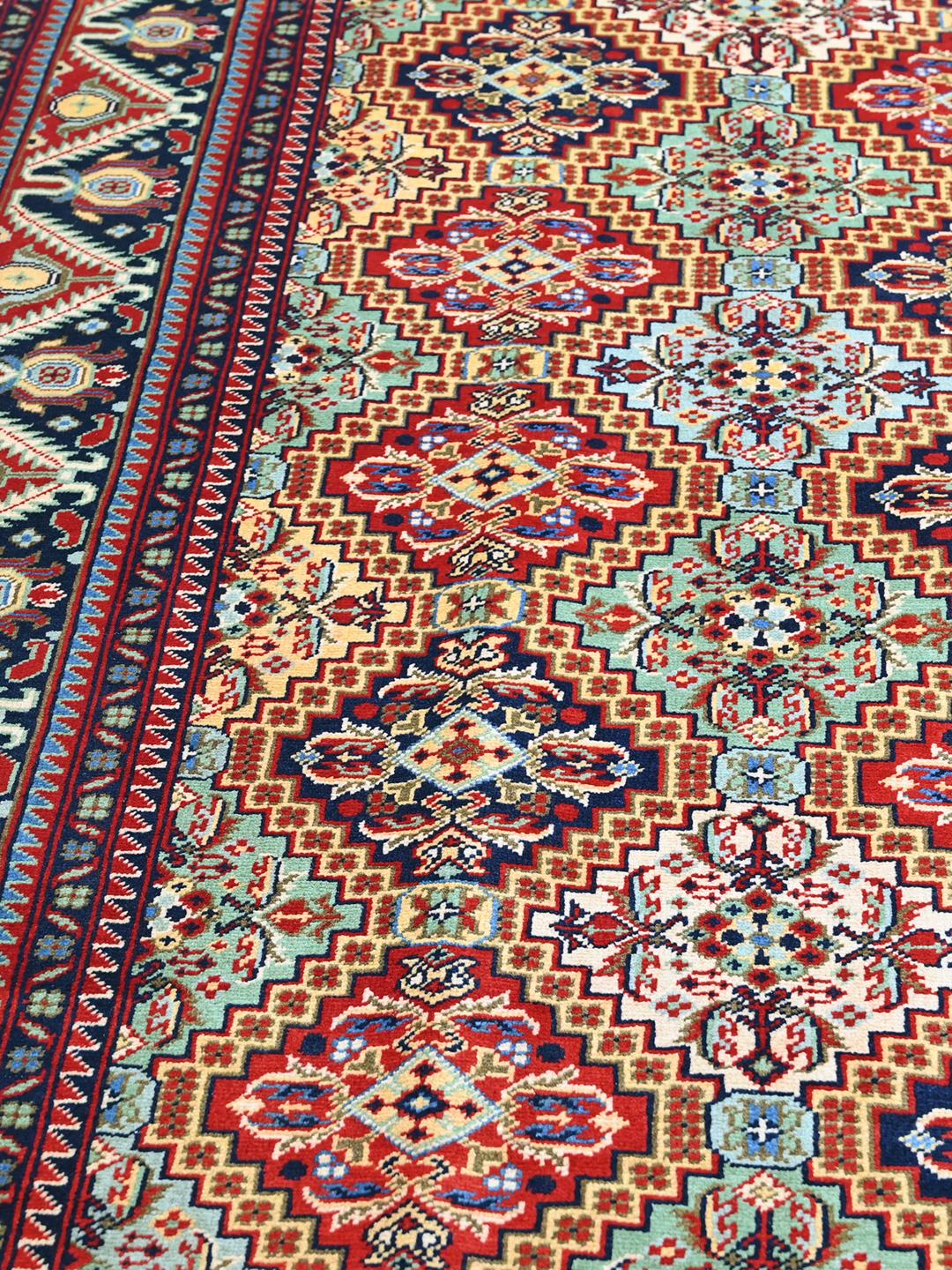 Handmade runner rug from Afghanistan in red with traditional patterns.