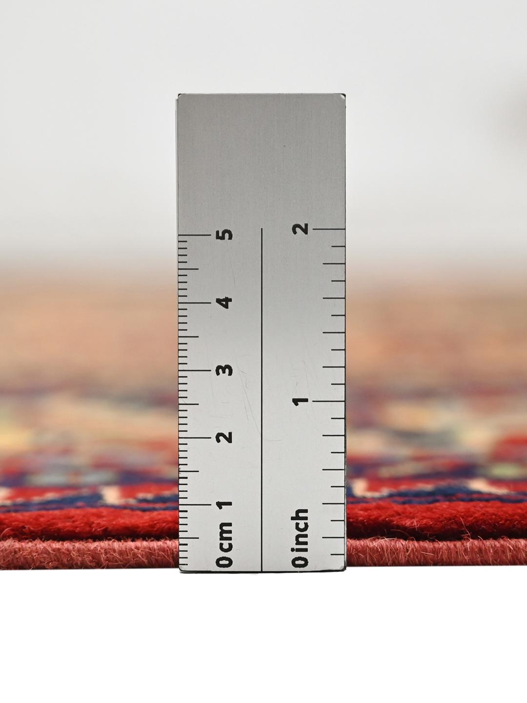 Handmade runner rug from Afghanistan in red with traditional patterns.