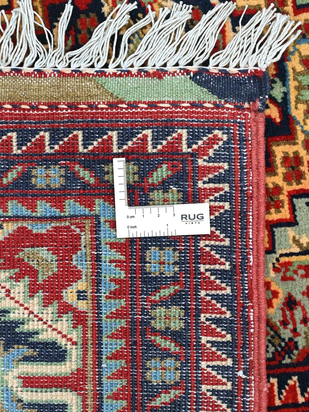 Handmade runner rug from Afghanistan in red with traditional patterns.