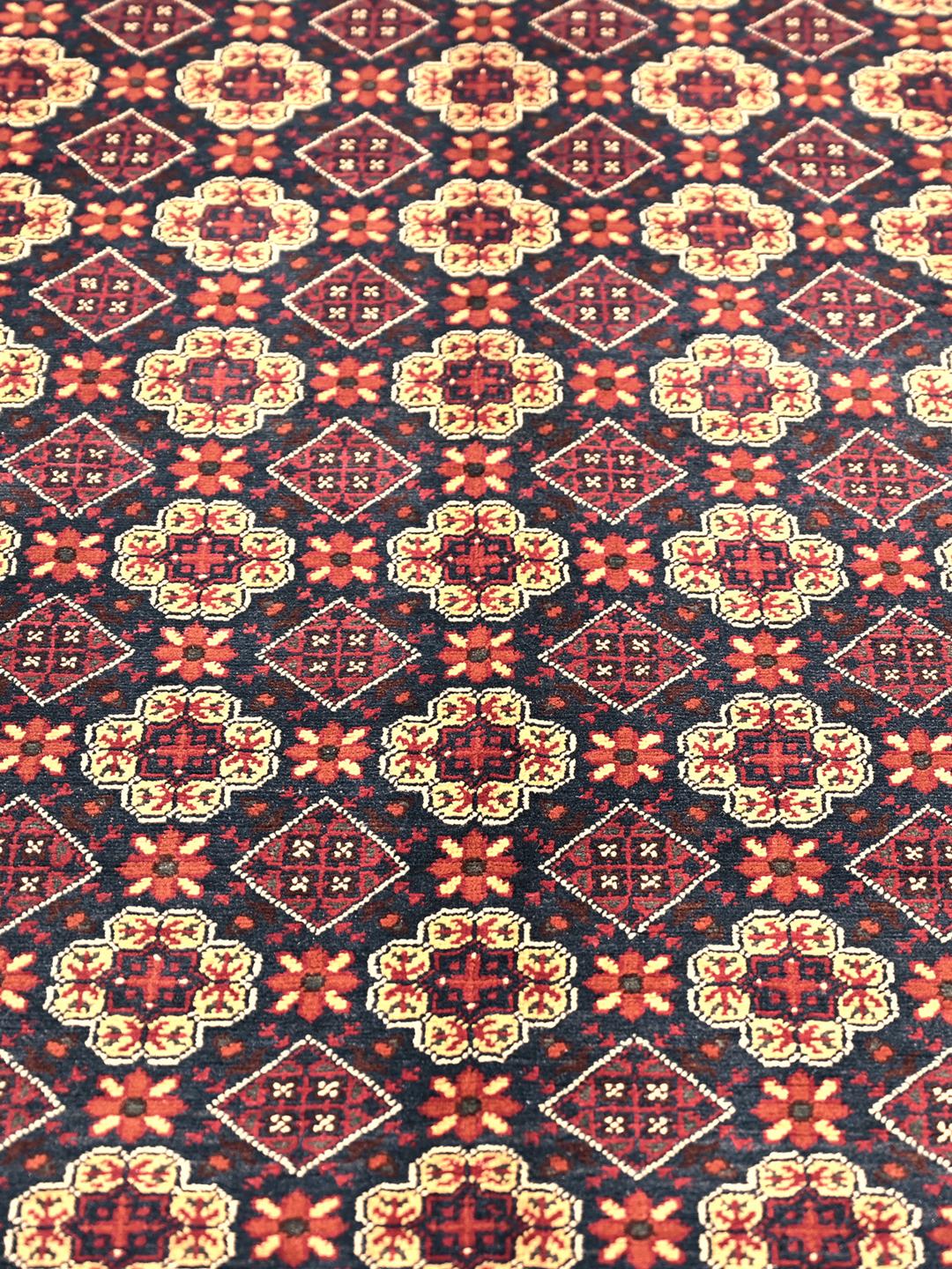 Et smukt håndknyttet Kunduz-tæppe fra Afghanistan med et mørkerødt og beige geometrisk design.