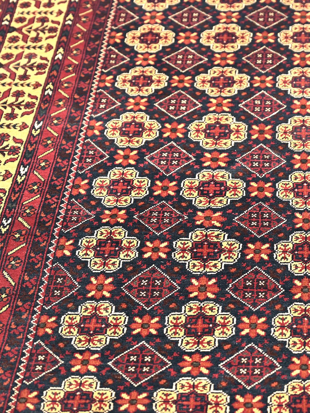 Et smukt håndknyttet Kunduz-tæppe fra Afghanistan med et mørkerødt og beige geometrisk design.