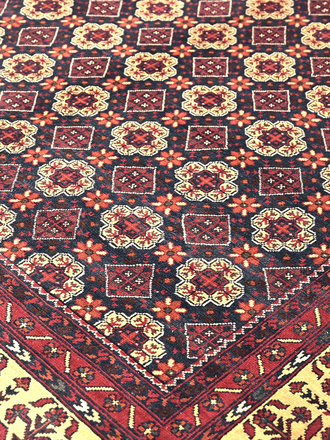 Et smukt håndknyttet Kunduz-tæppe fra Afghanistan med et mørkerødt og beige geometrisk design.