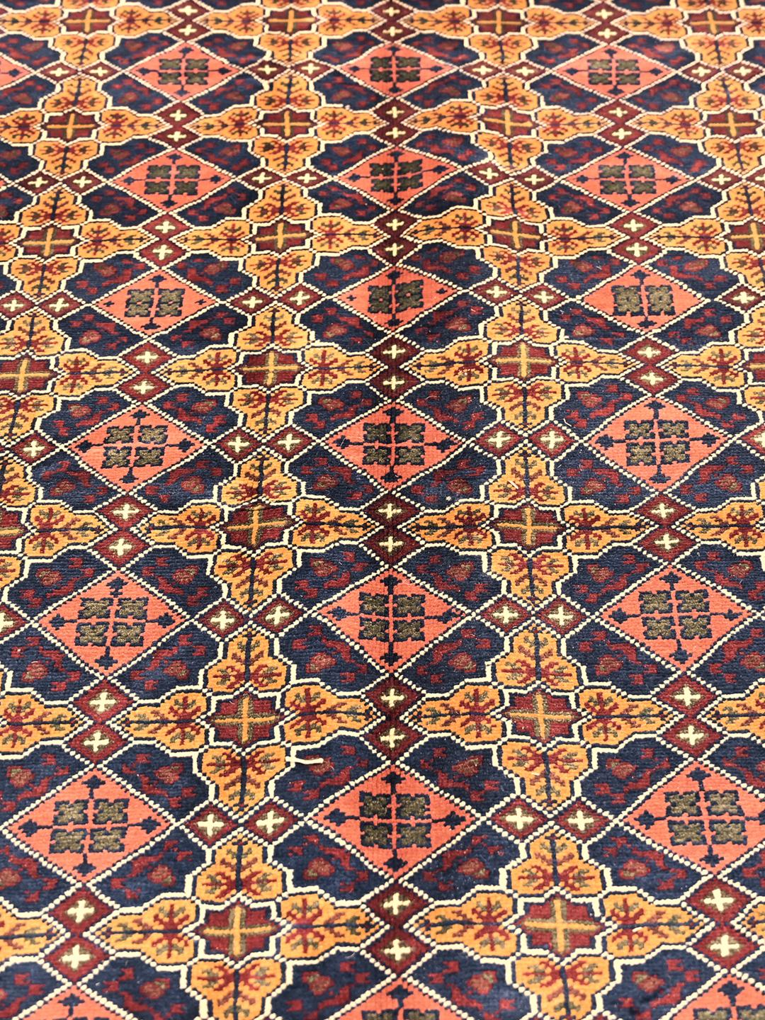 A large hand-knotted Kunduz rug from Afghanistan featuring a dark-red and multicolour geometric pattern.