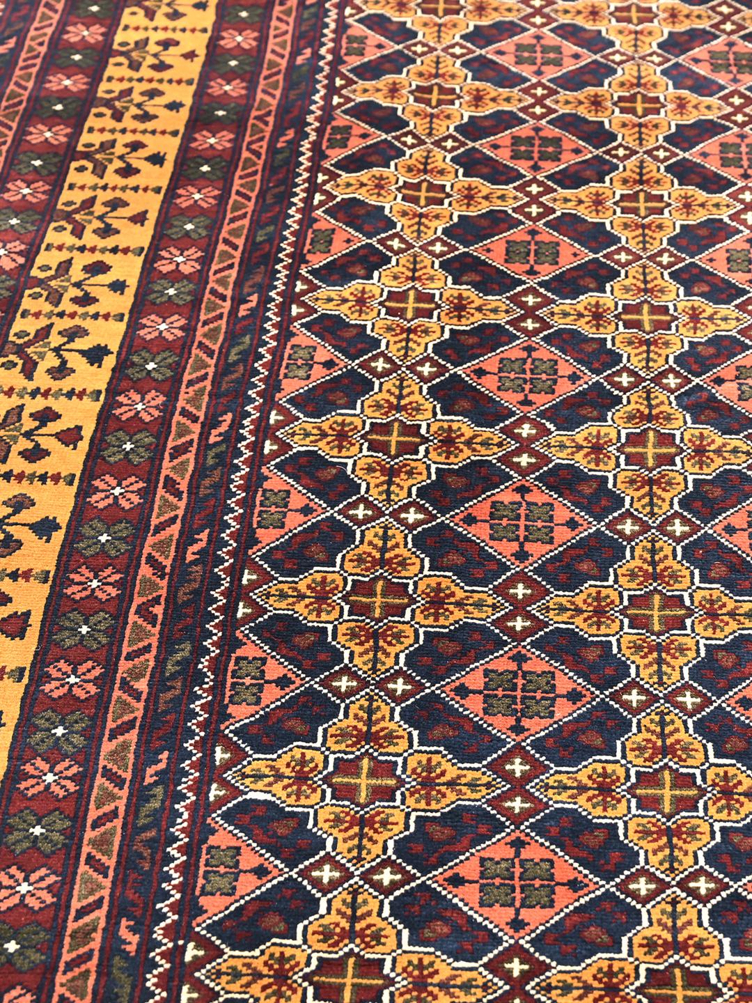 A large hand-knotted Kunduz rug from Afghanistan featuring a dark-red and multicolour geometric pattern.