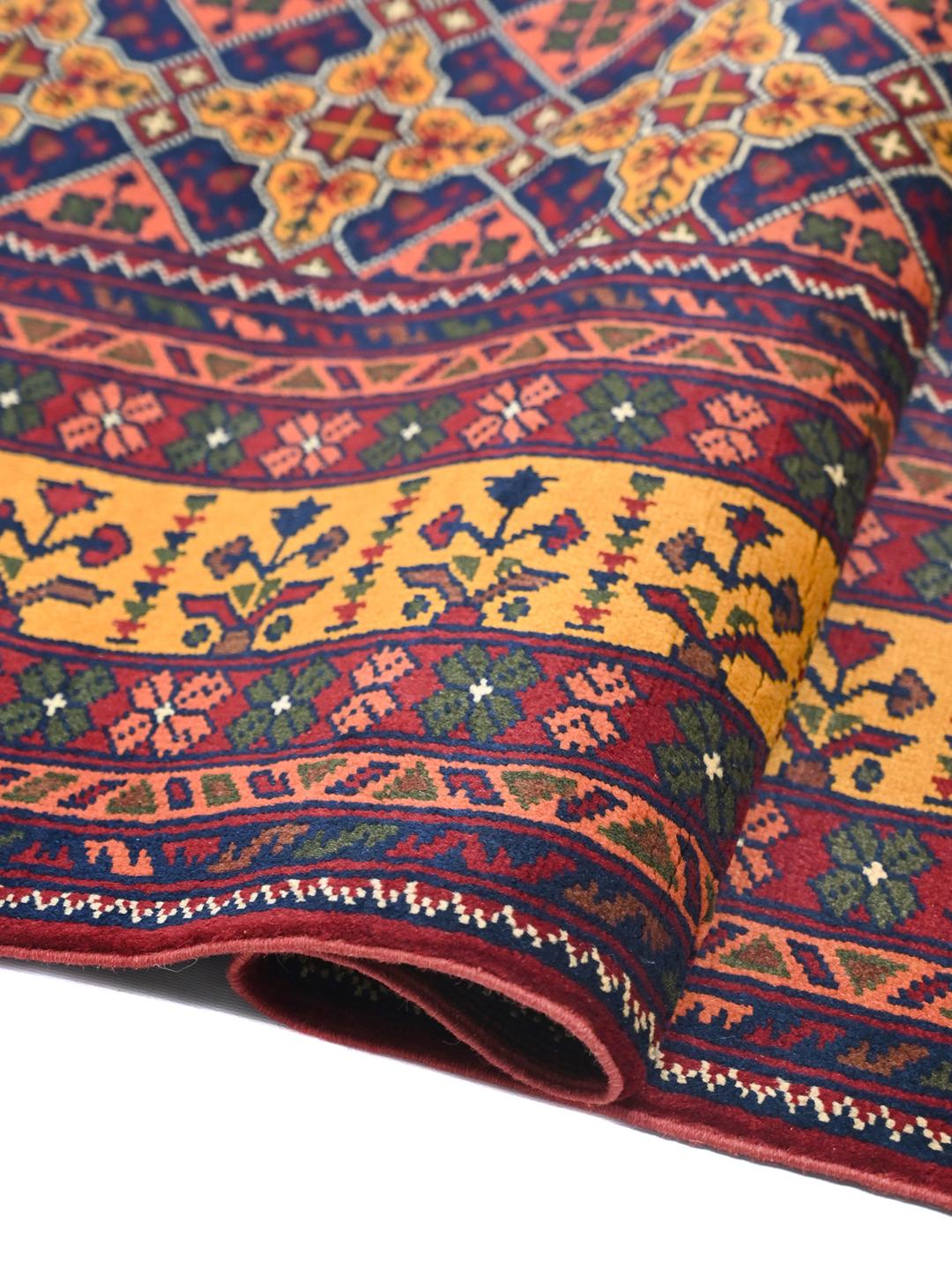 A large hand-knotted Kunduz rug from Afghanistan featuring a dark-red and multicolour geometric pattern.