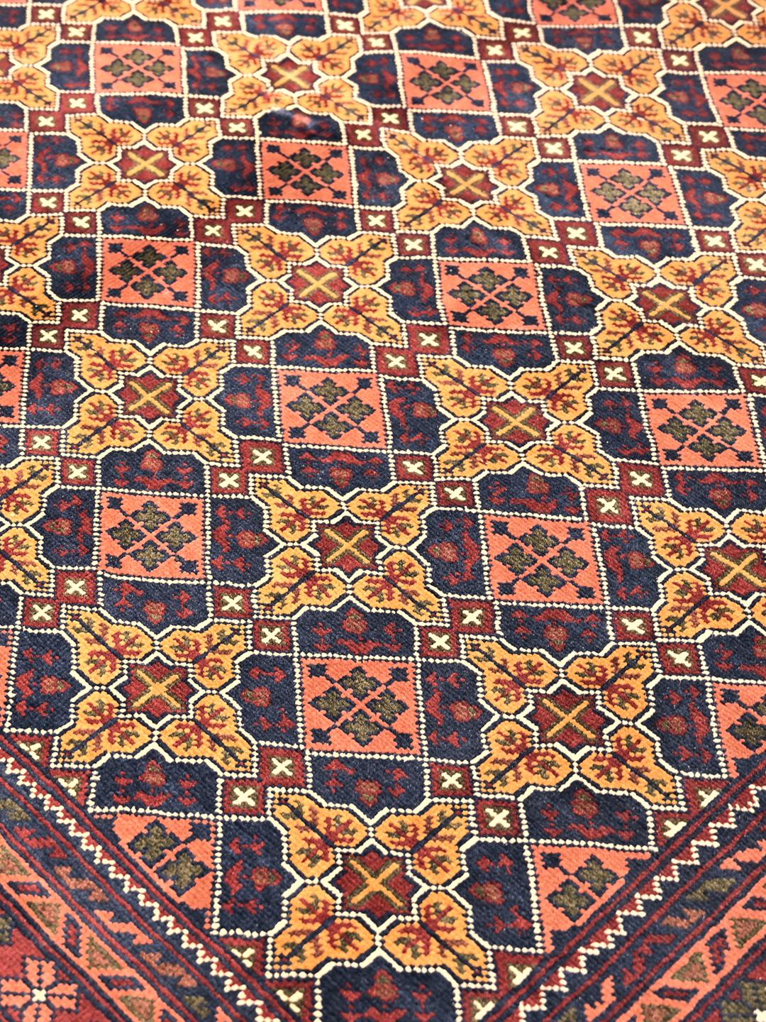 A large hand-knotted Kunduz rug from Afghanistan featuring a dark-red and multicolour geometric pattern.