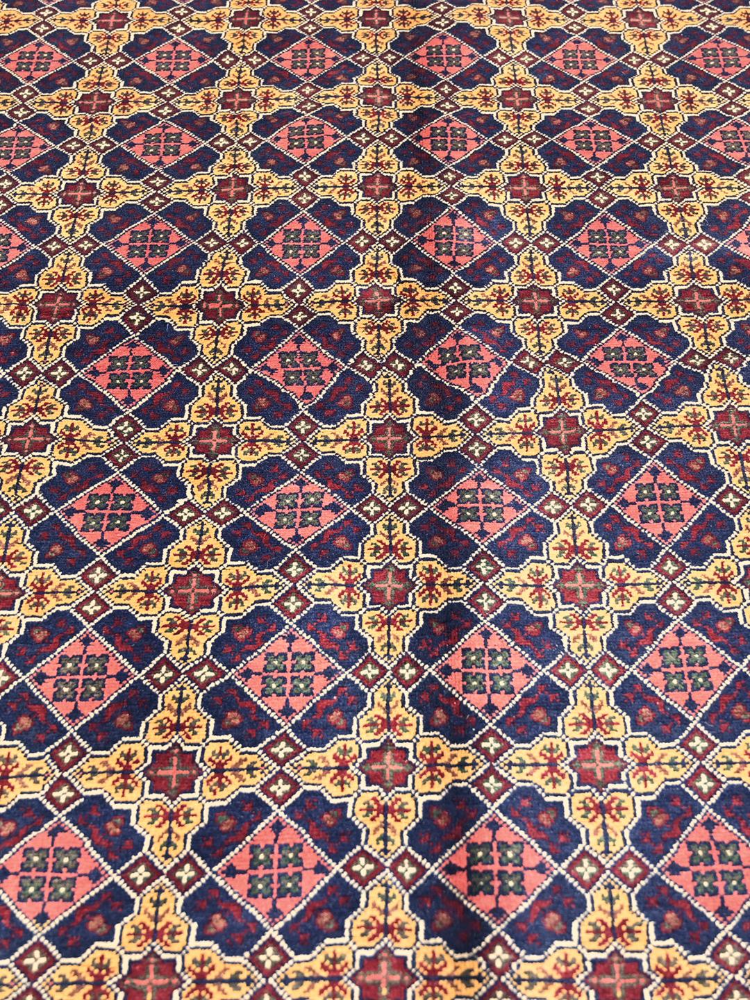A hand-knotted Kunduz rug from Afghanistan with a dark-red and yellow geometric pattern.