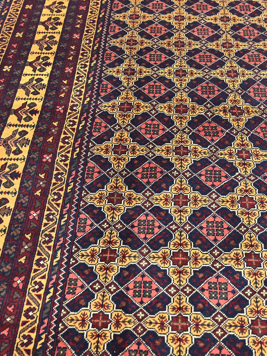 A hand-knotted Kunduz rug from Afghanistan with a dark-red and yellow geometric pattern.