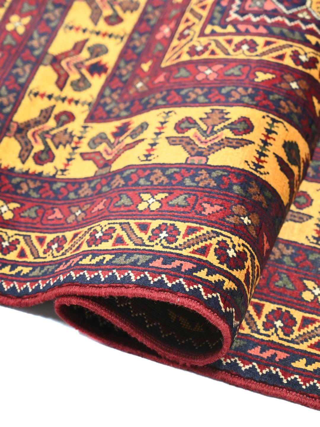 A hand-knotted Kunduz rug from Afghanistan with a dark-red and yellow geometric pattern.