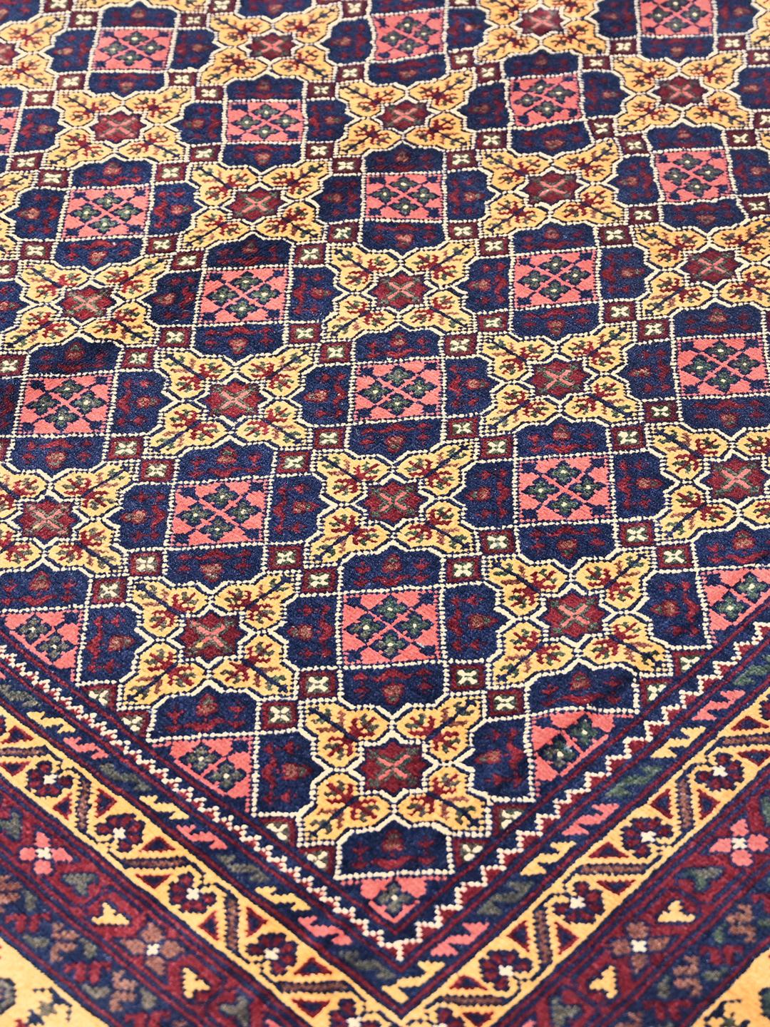 A hand-knotted Kunduz rug from Afghanistan with a dark-red and yellow geometric pattern.